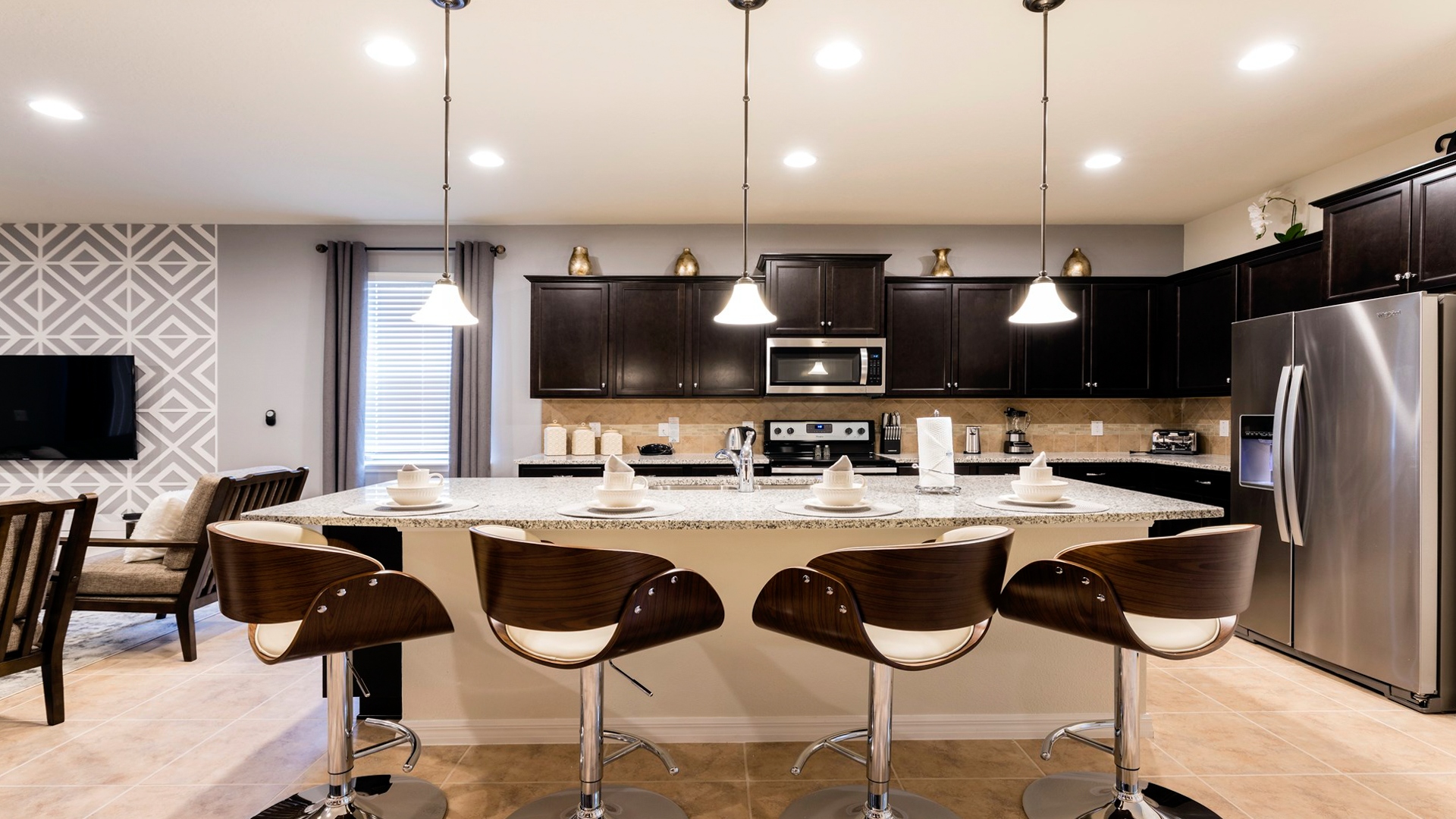 Fully equipped gourmet kitchen with granite countertops and stylish bar seating.