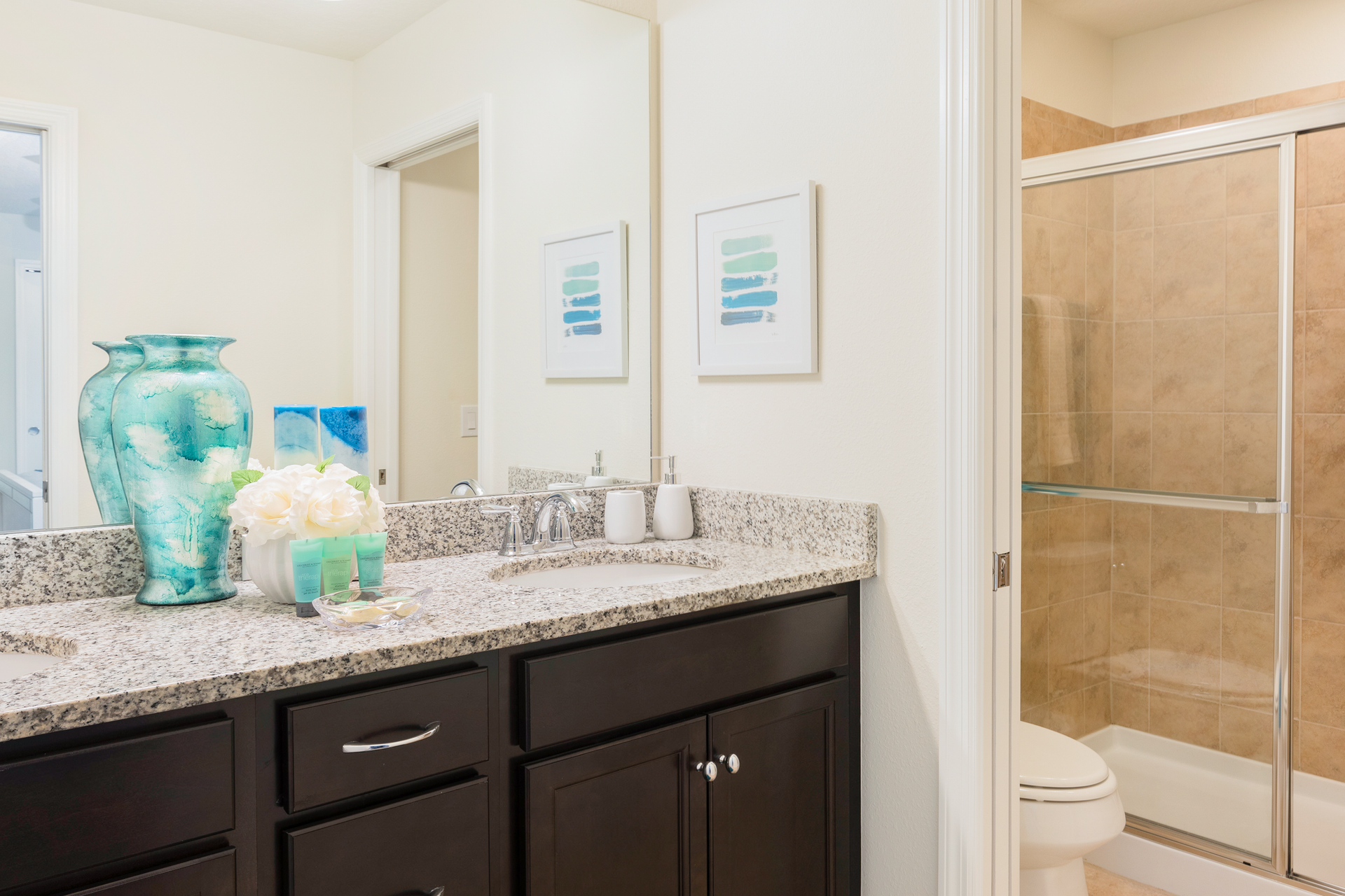 Elegant bathroom with double sinks, granite counters, and a spacious walk-in shower.
