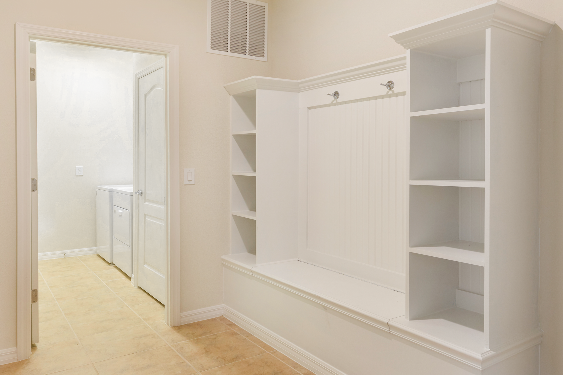 Convenient mudroom with built-in storage and easy access to laundry area.