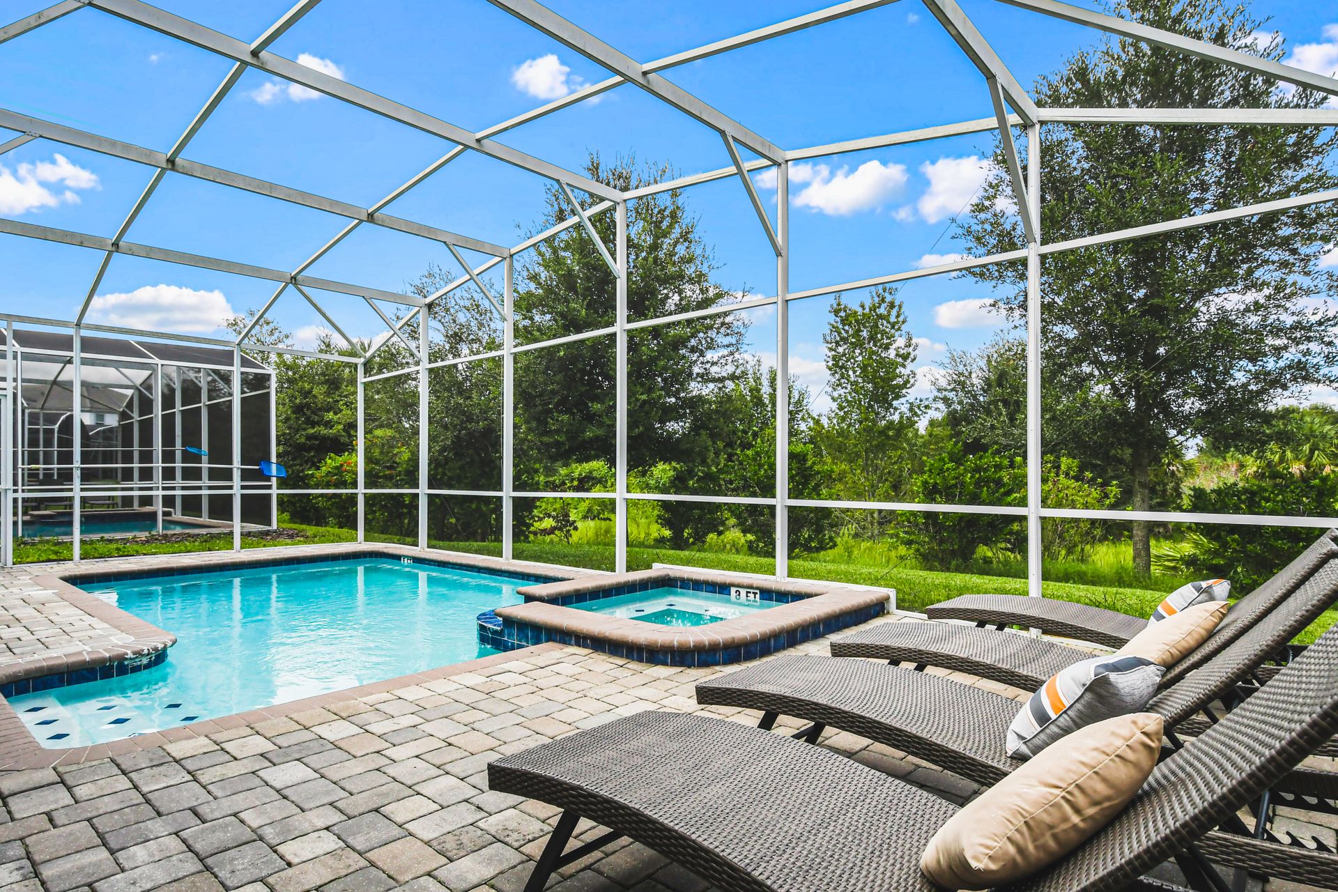 Outdoor pool area with a screened enclosure, offering a private and protected space for relaxation and enjoyment