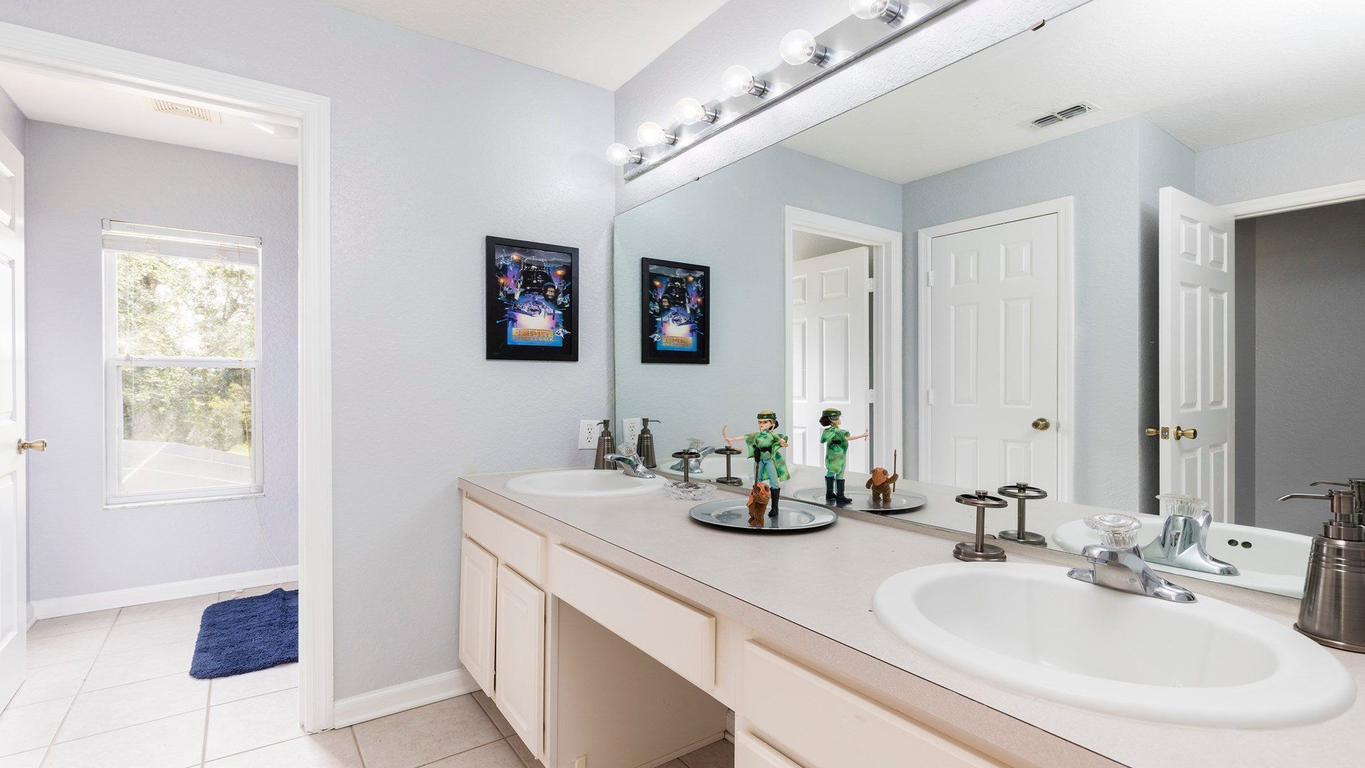 Spacious bathroom with dual sinks, fun decor, and bright natural light!