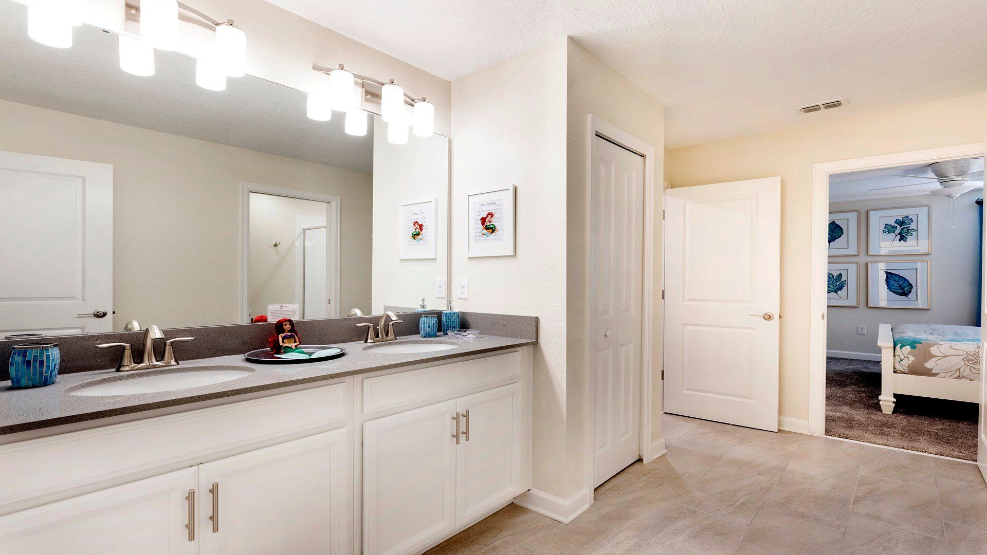 Spacious double-vanity bathroom with modern lighting and decor.