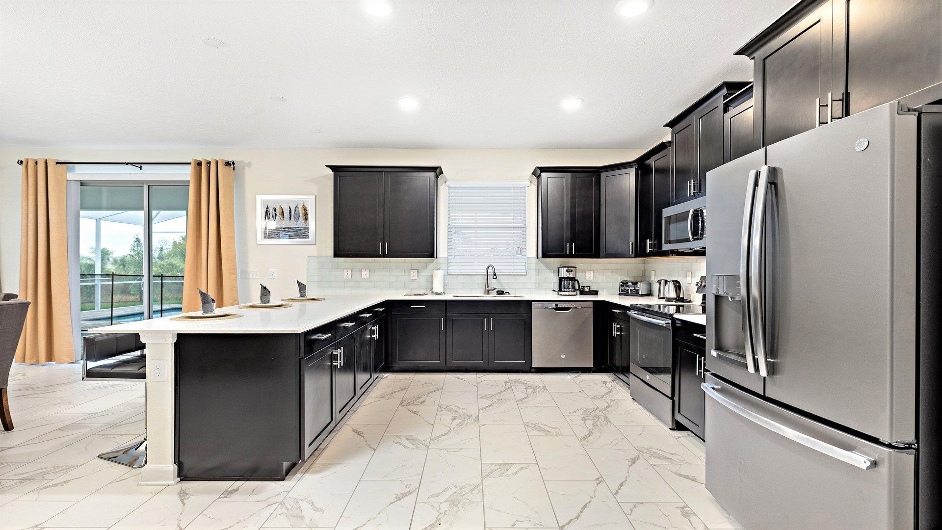 This kitchen features gleaming appliances, marble floors, and plenty of counter space for whipping up culinary masterpieces. Breakfast bar for coffee catch-ups too!