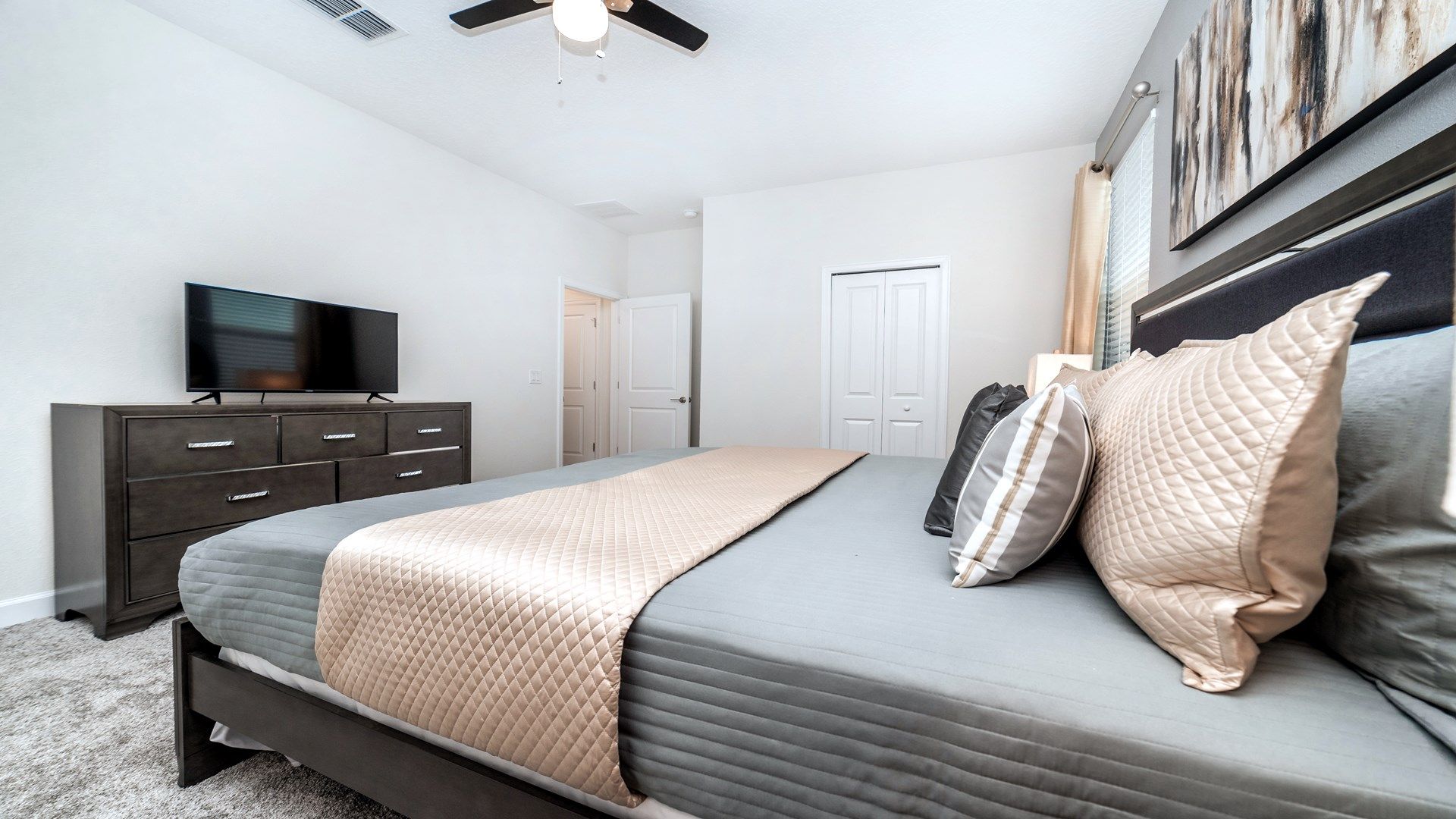Elegant bedroom with a king bed, sleek furnishings, and a TV!