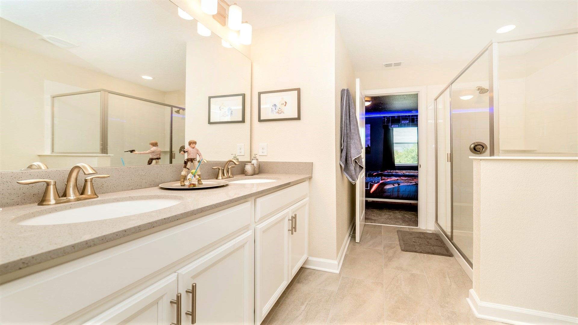 Bright bathroom with dual sinks, walk-in shower, and fun decor touches!