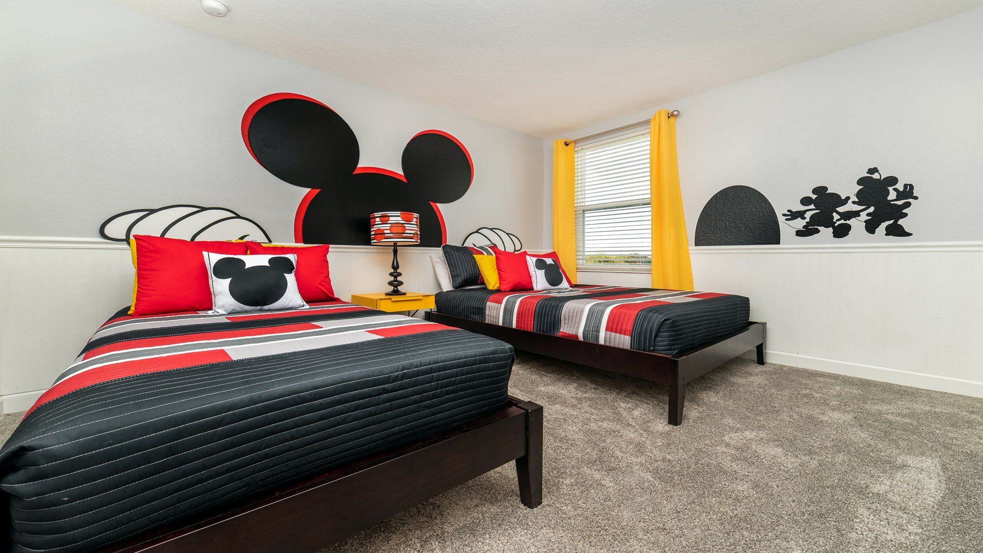 Fun Mickey Mouse-themed bedroom with twin beds and vibrant decor!