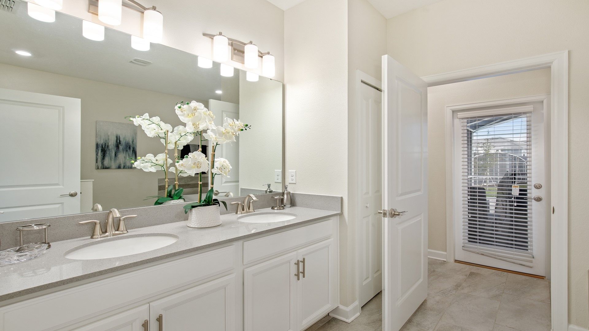 Bright dual-sink bathroom with modern decor and private patio access