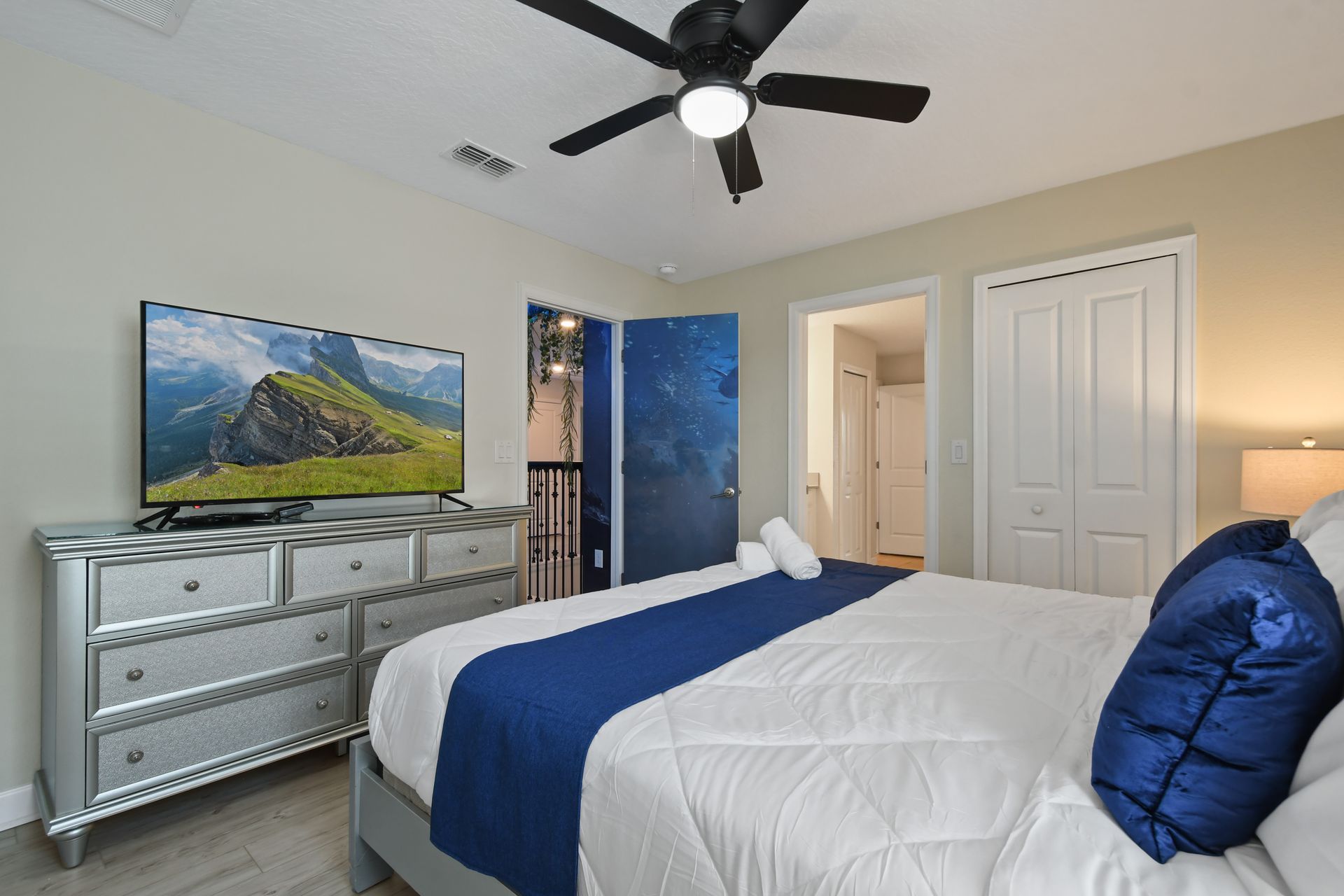 Cozy bedroom with modern decor, HDTV, and ocean-inspired door!