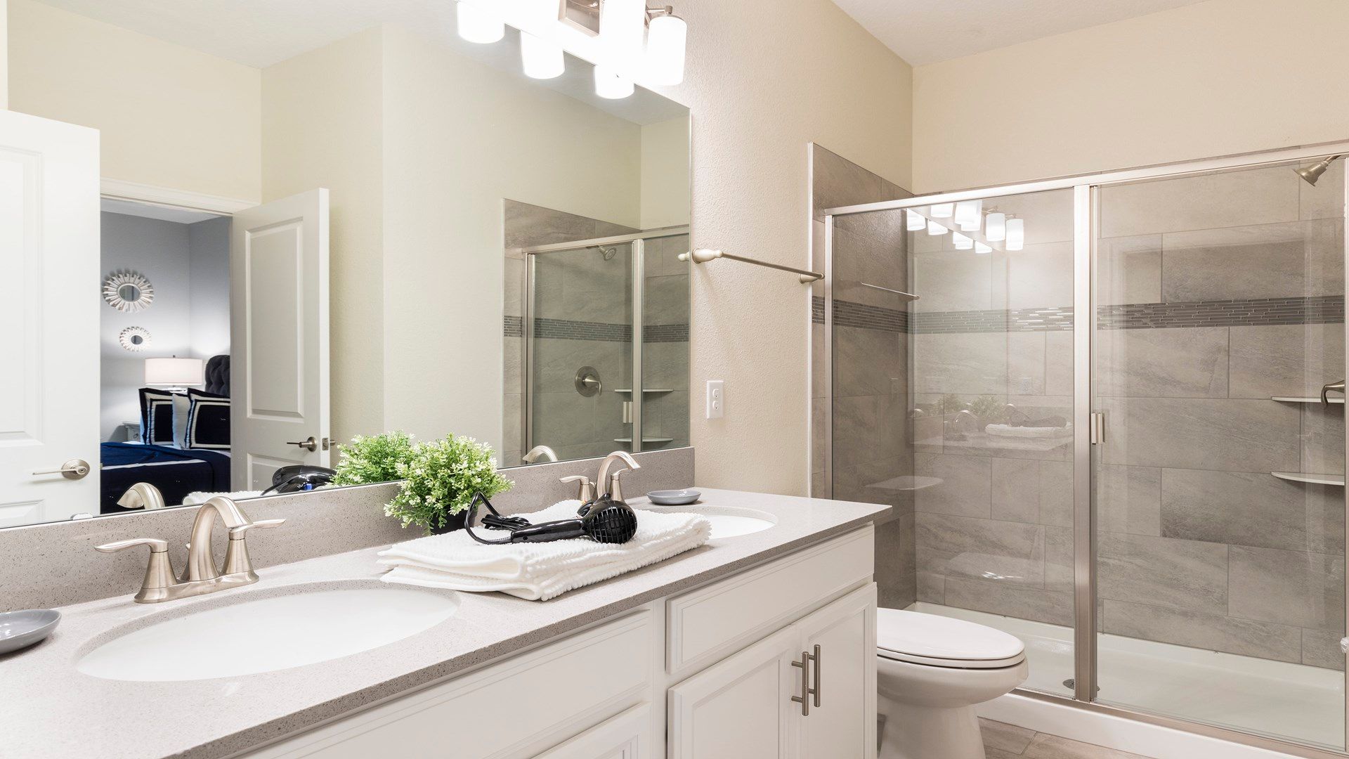 Modern bathroom with dual sinks, glass shower, and sleek design!