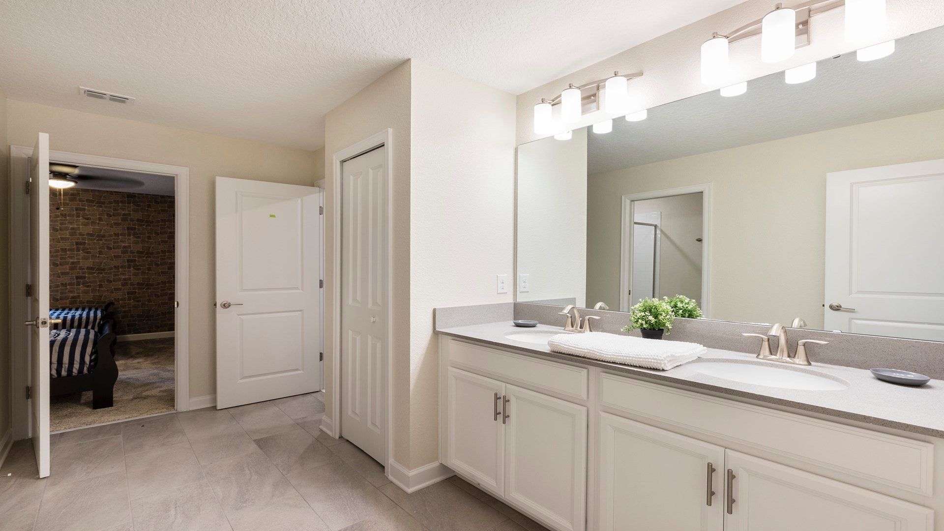Spacious bathroom with dual sinks, modern lighting, and privacy!