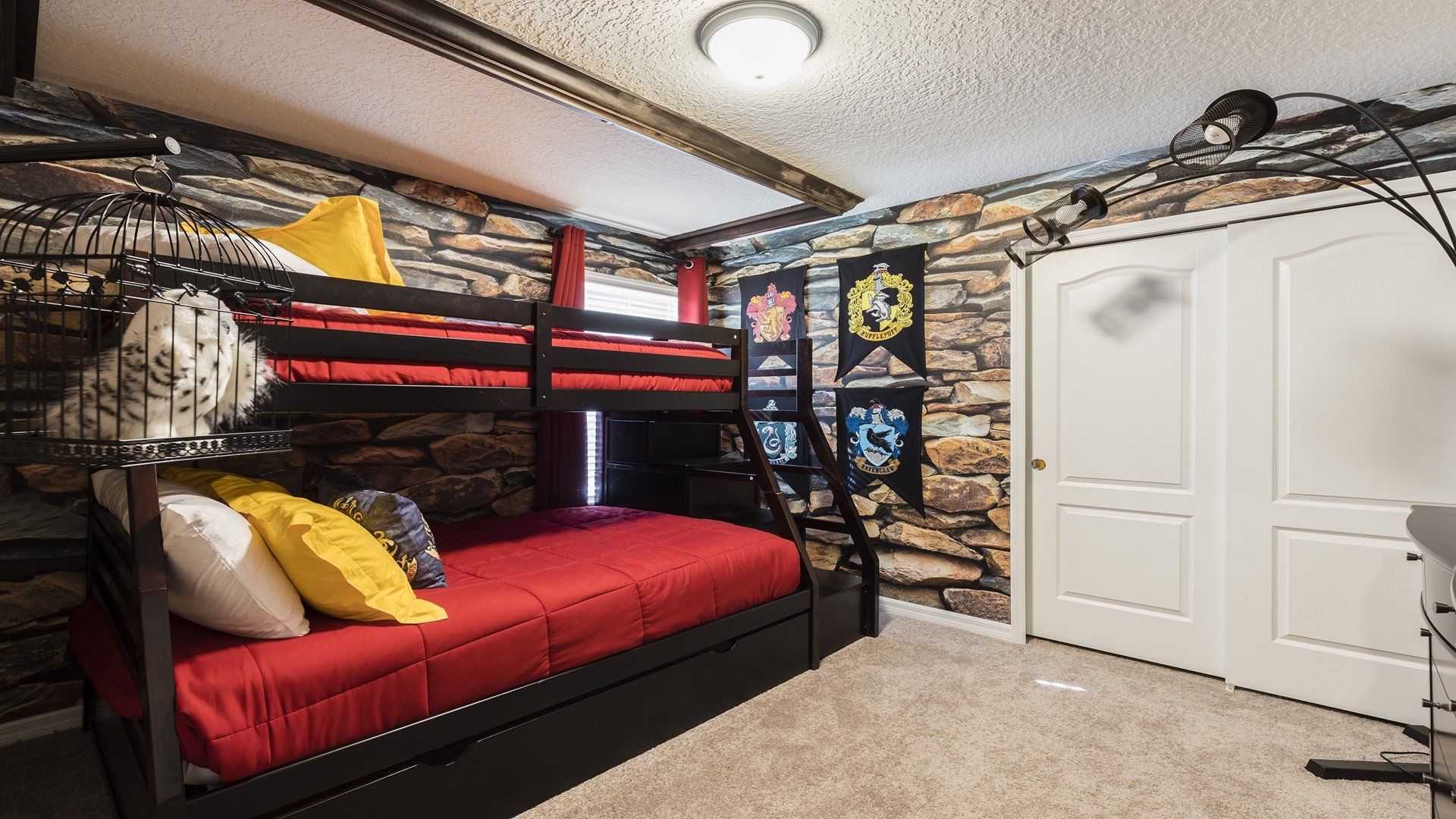 Wizard-themed bunk room with stone walls, house banners, and magical owl decor for a cozy adventure.