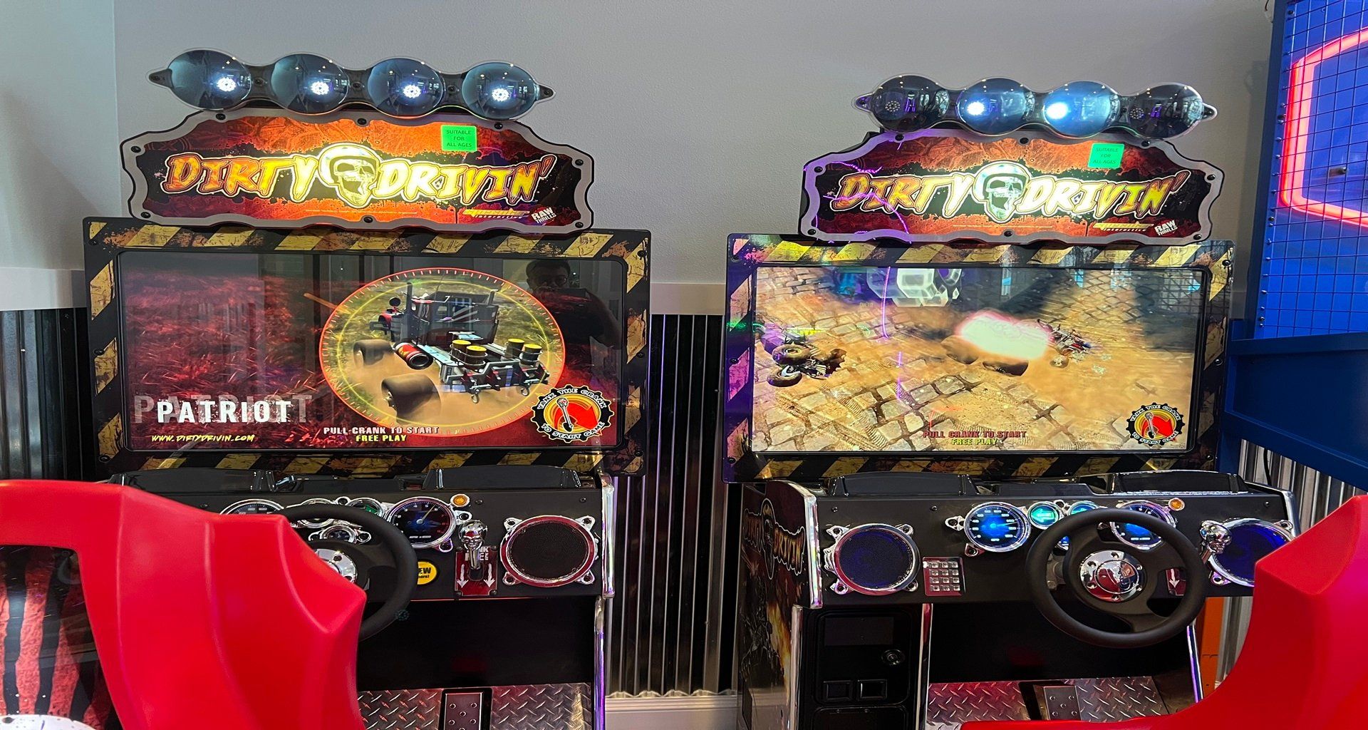 Exciting arcade racing game setup with vibrant screens, steering wheels, and controls.