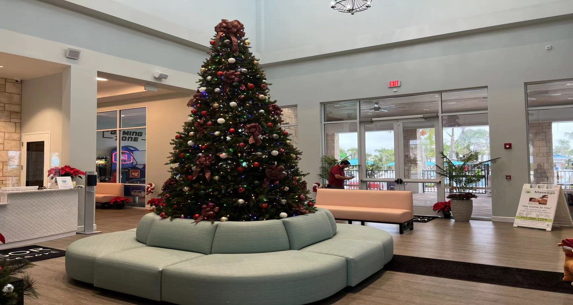 Festive lobby with a grand Christmas tree, cozy seating, and a view of the Gaming Zone!