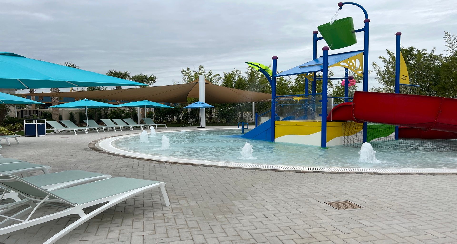Vibrant splash pad with colorful slides, lounge chairs, and refreshing fountains!