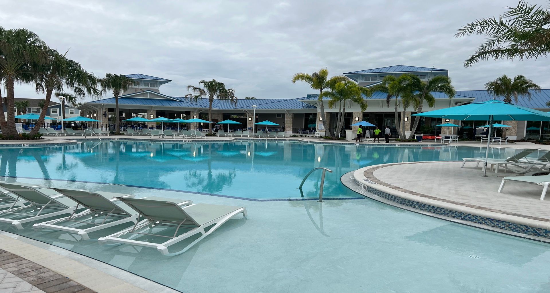 Luxurious poolside oasis with crystal-clear waters, palm trees, and shaded lounges.