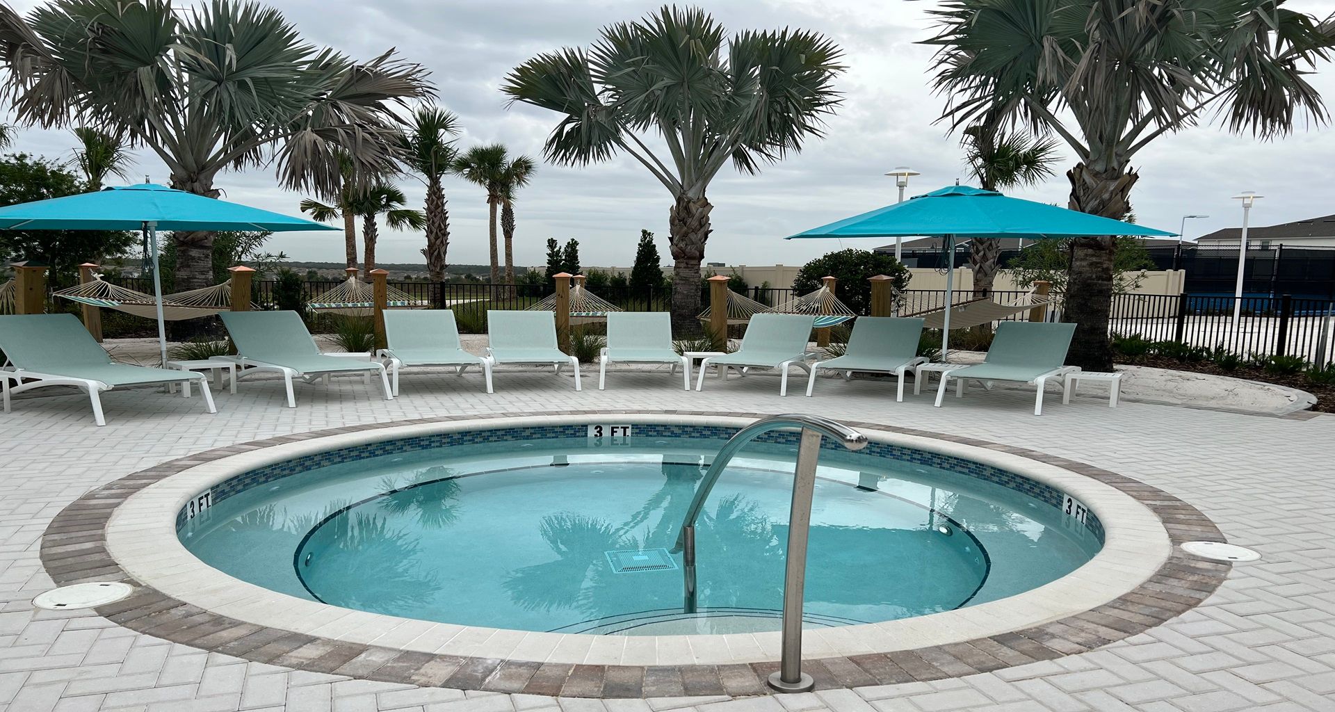 Unwind by the tranquil hot tub, surrounded by lounge chairs, hammocks, and palms.