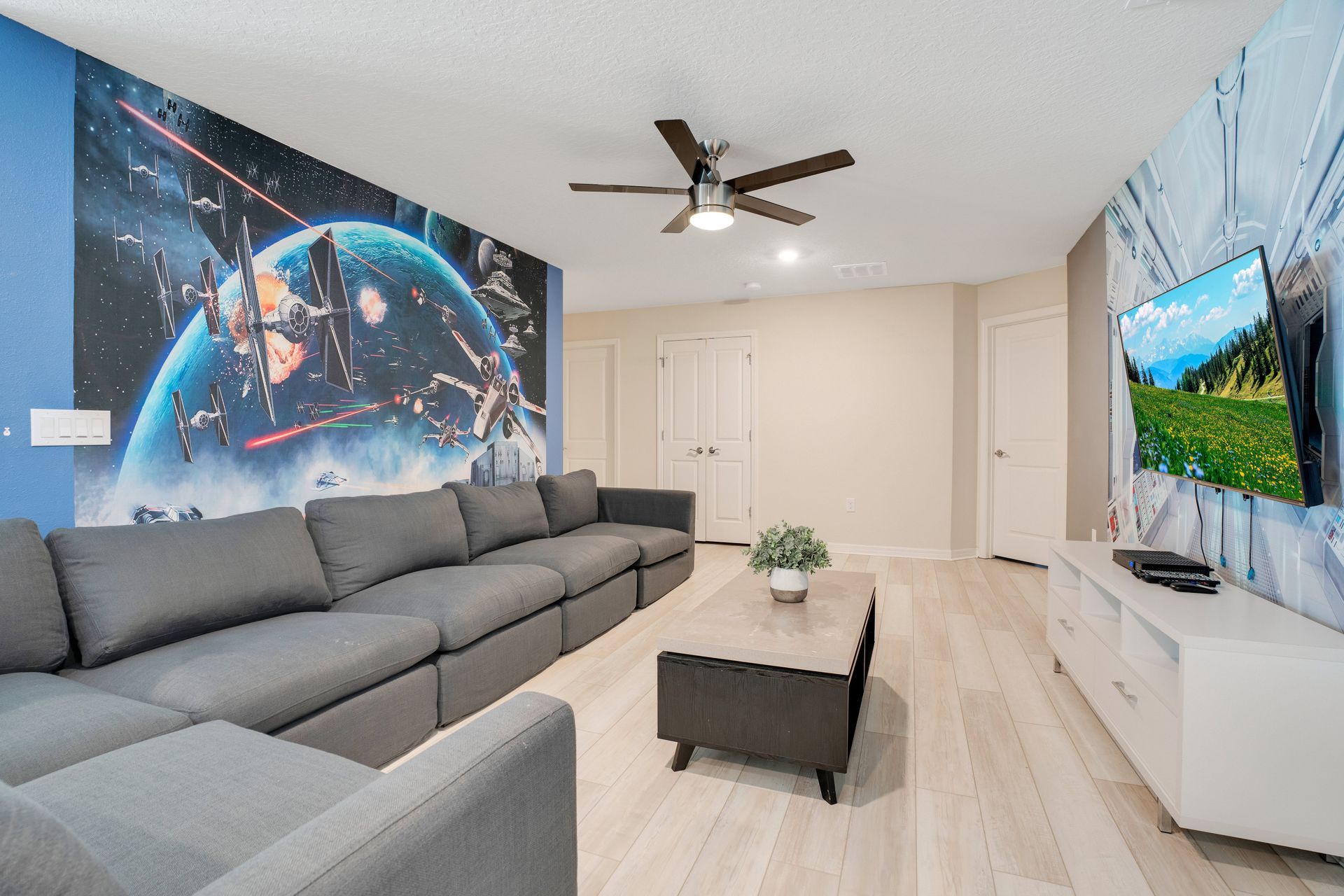 Cozy sci-fi-themed room with a large sectional, TV, and space-inspired decor.