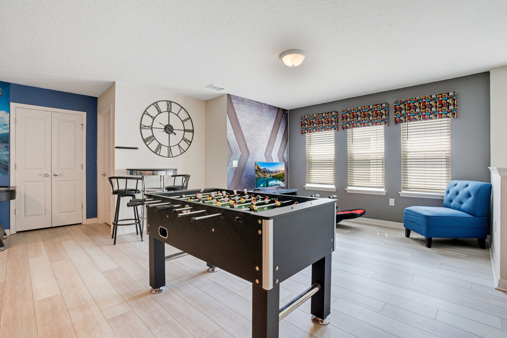 Stylish game room with a foosball table, bar seating, and colorful accents.