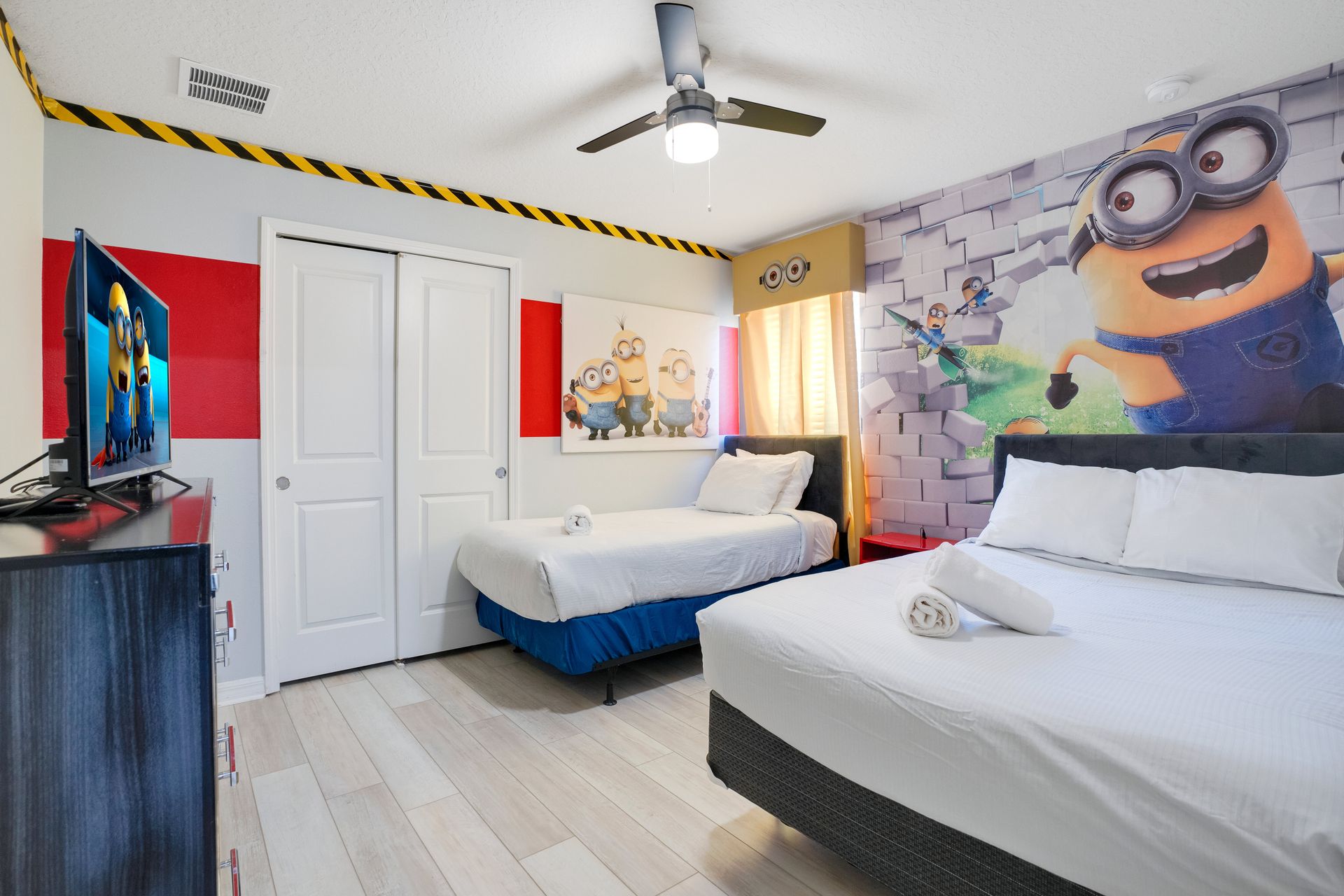 Playful Minions-themed bedroom with colorful murals and cozy twin beds.