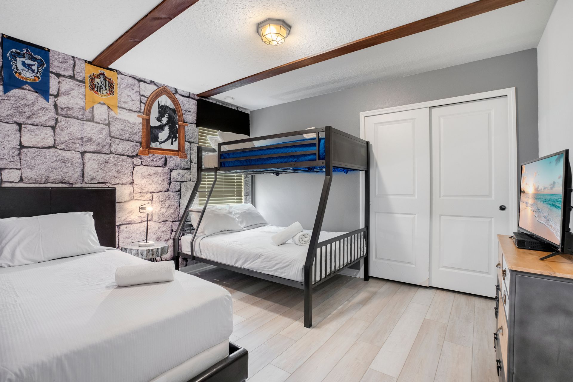 Magical castle-inspired bedroom featuring bunk beds, stone walls, and house banners.