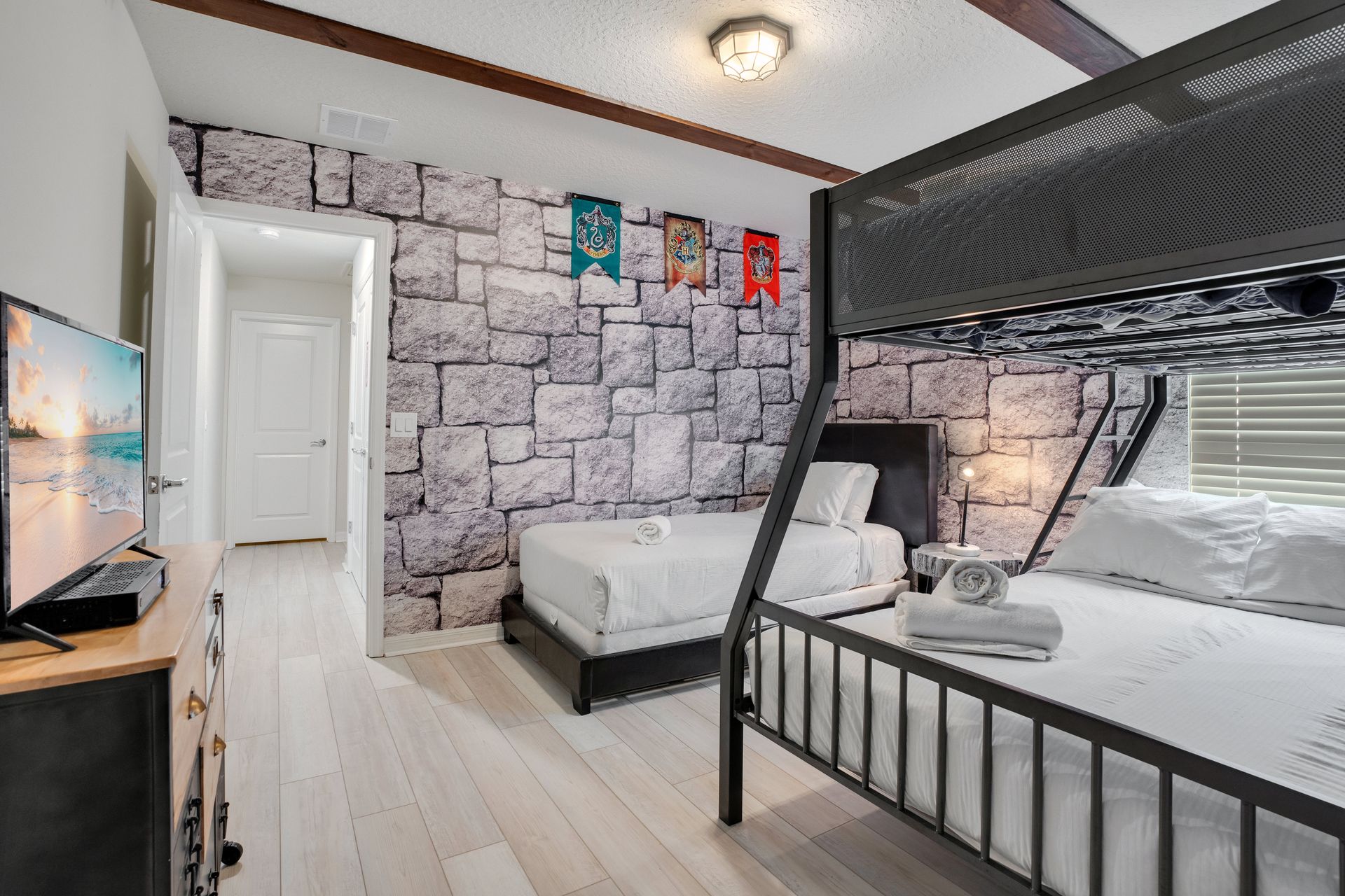 Wizard-themed bedroom with castle stone walls, bunk beds, and house banners.