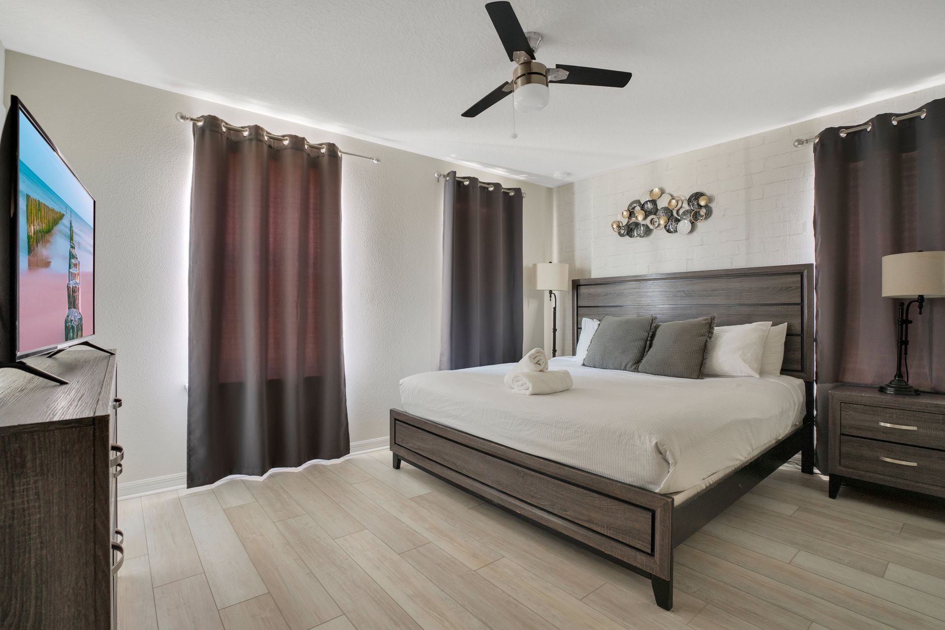 Modern bedroom with dark wood furniture, neutral decor, and cozy lighting.