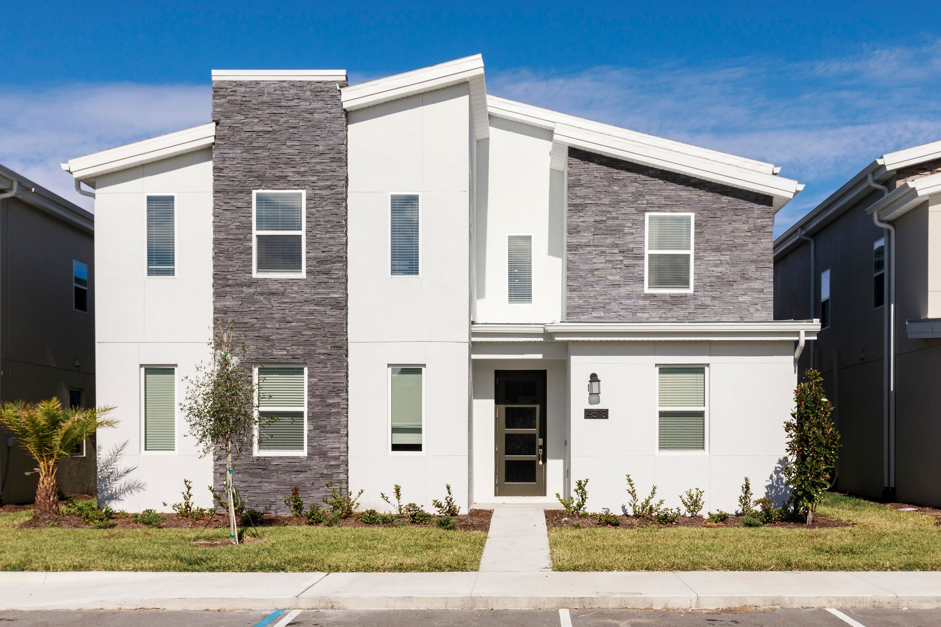 Modern two-story home with stone accents, clean lines, and landscaped entry.