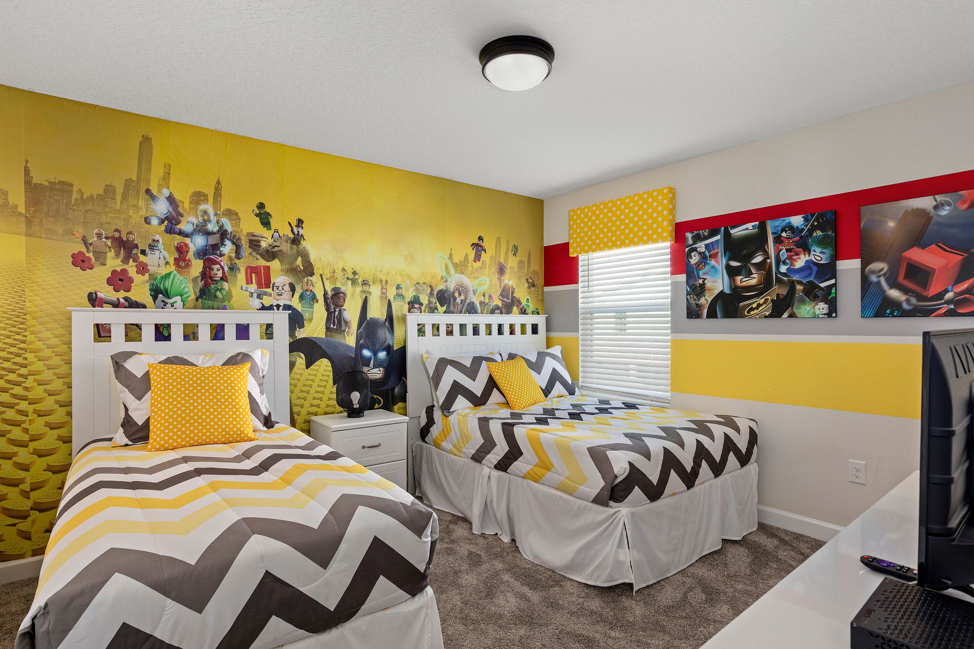 Lively LEGO-themed room with bold colors, twin beds, and fun character decor.
