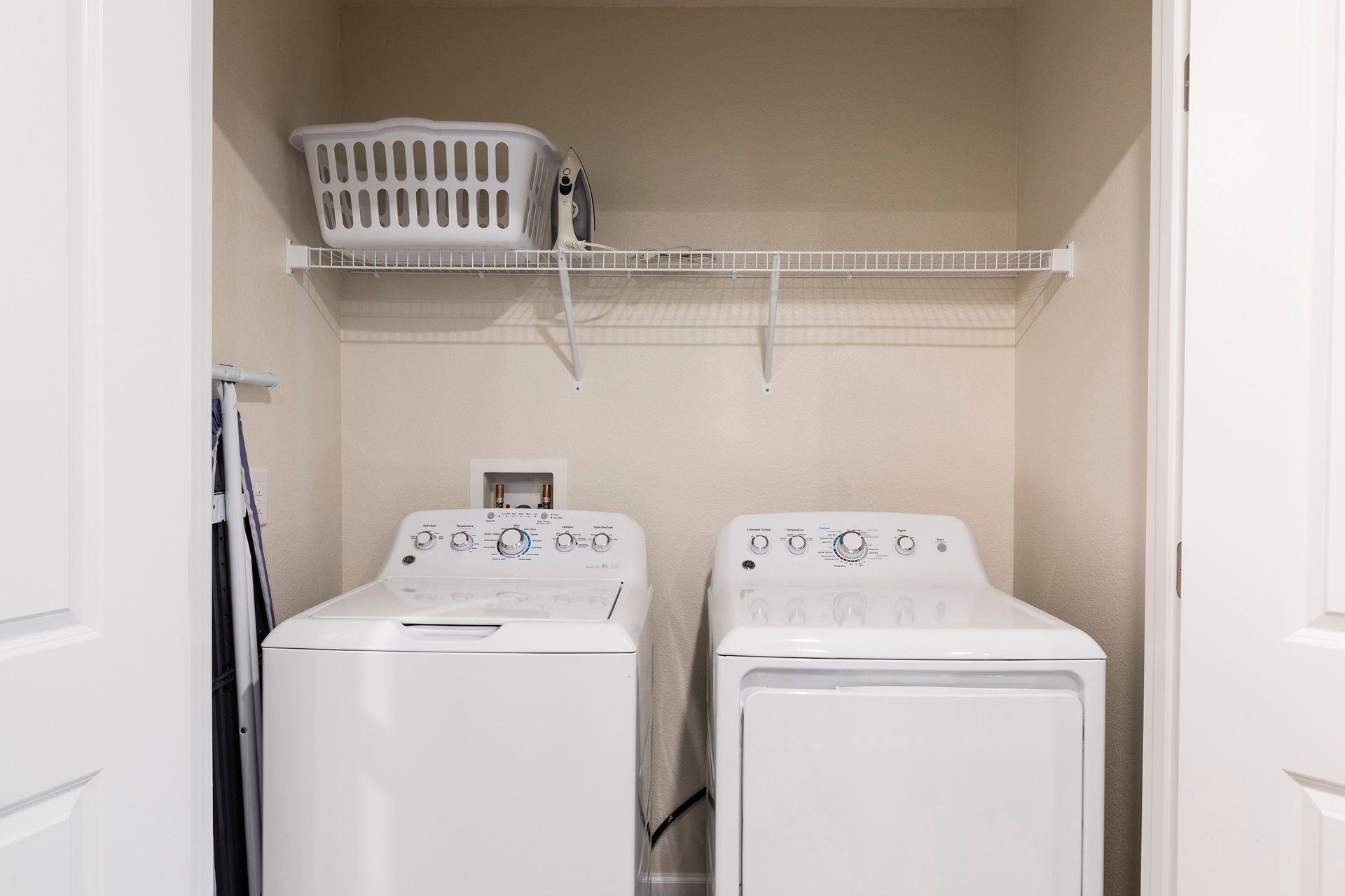 Convenient laundry area with washer, dryer, and shelving for easy organization.