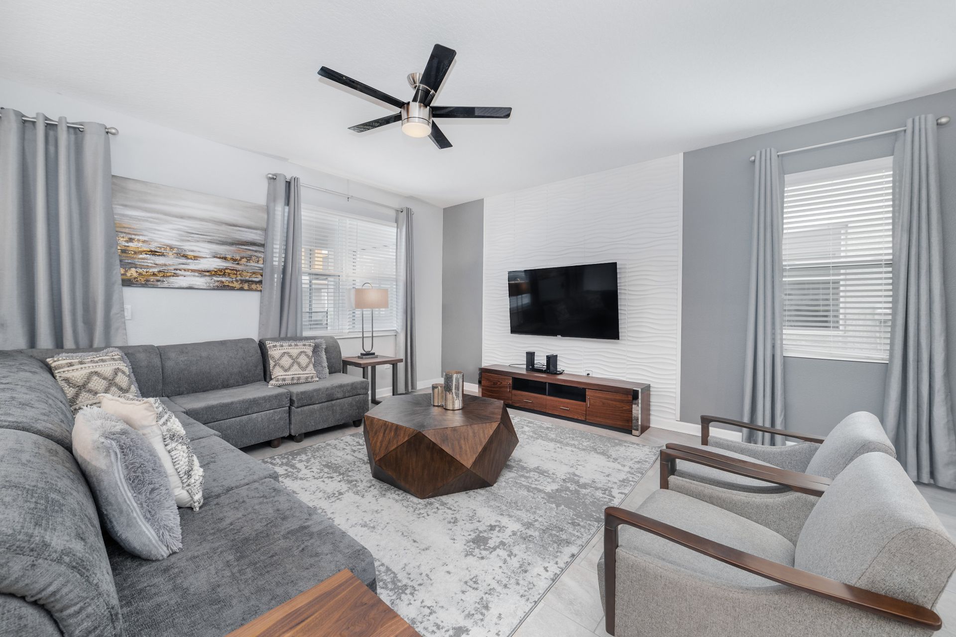 Spacious open-concept living area with modern decor, sleek kitchen, and dining.