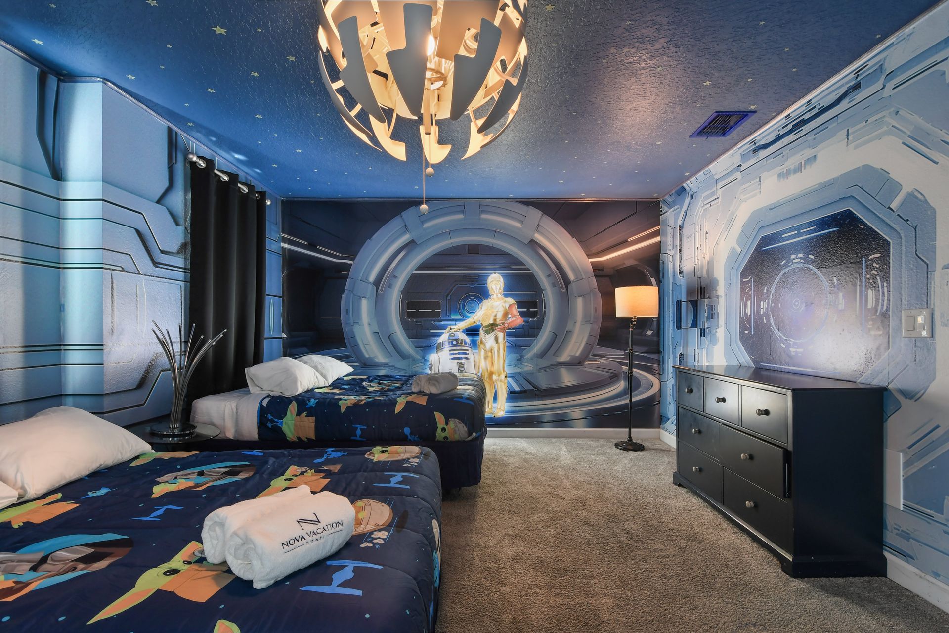 Galactic-themed room with starry decor, cozy beds, and futuristic ambiance.