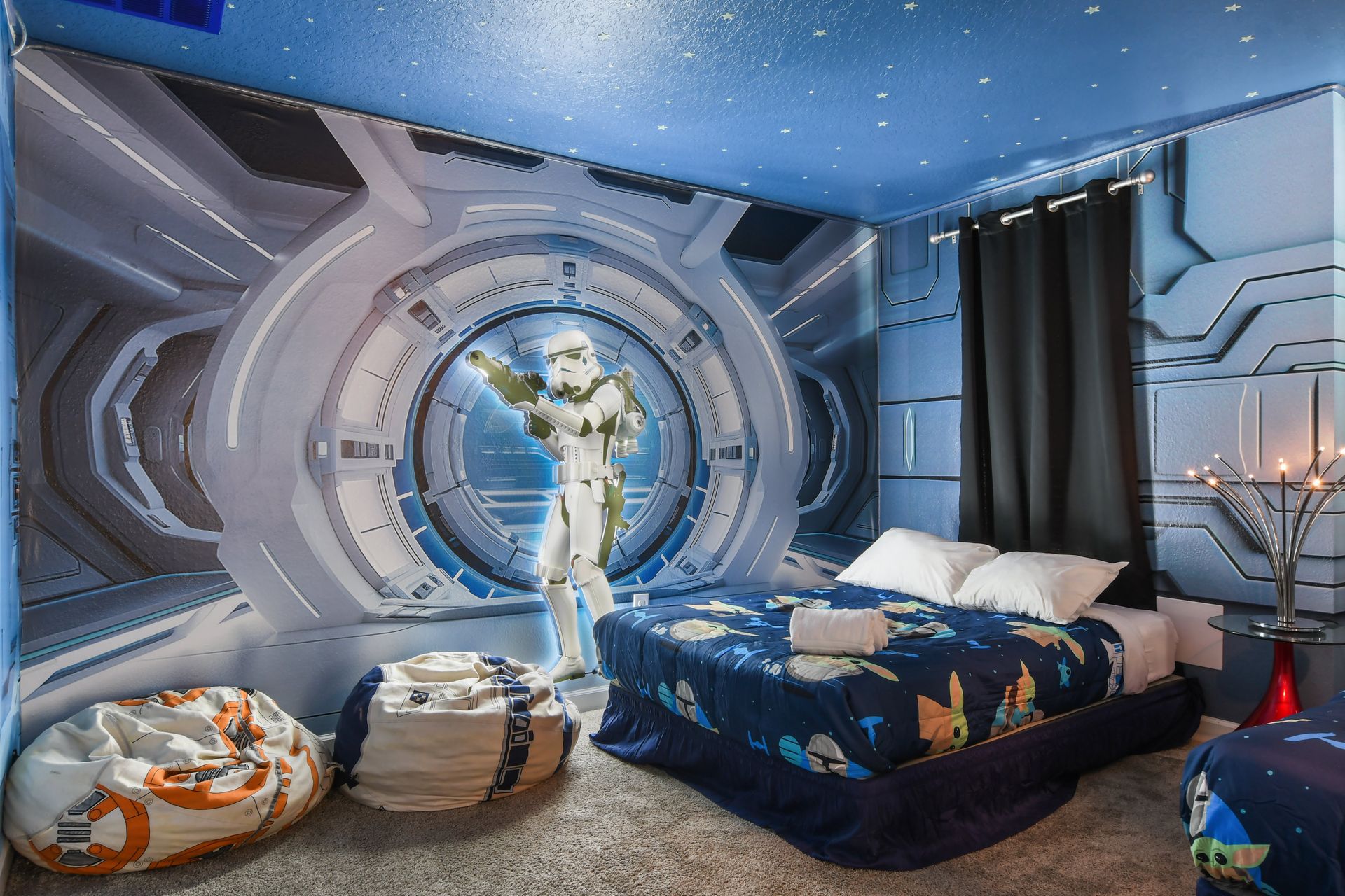 Galactic-themed room with starry decor, cozy beds, and futuristic ambiance.