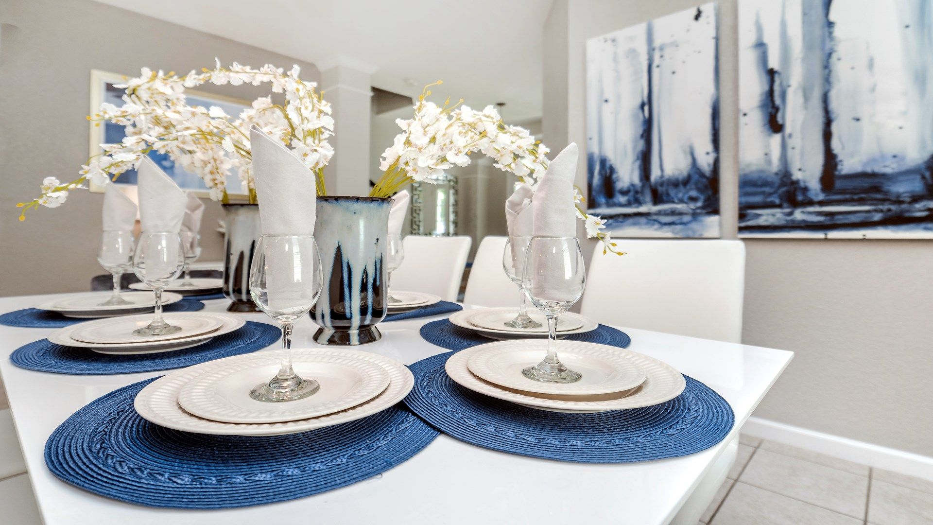 Elegant dining setup with vibrant blue placemats and fresh floral accents.