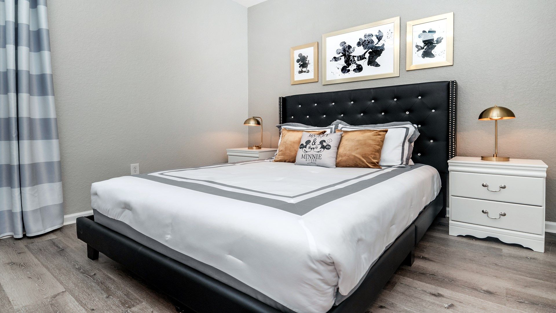 Chic bedroom with a bold black tufted bed and stylish striped accents.