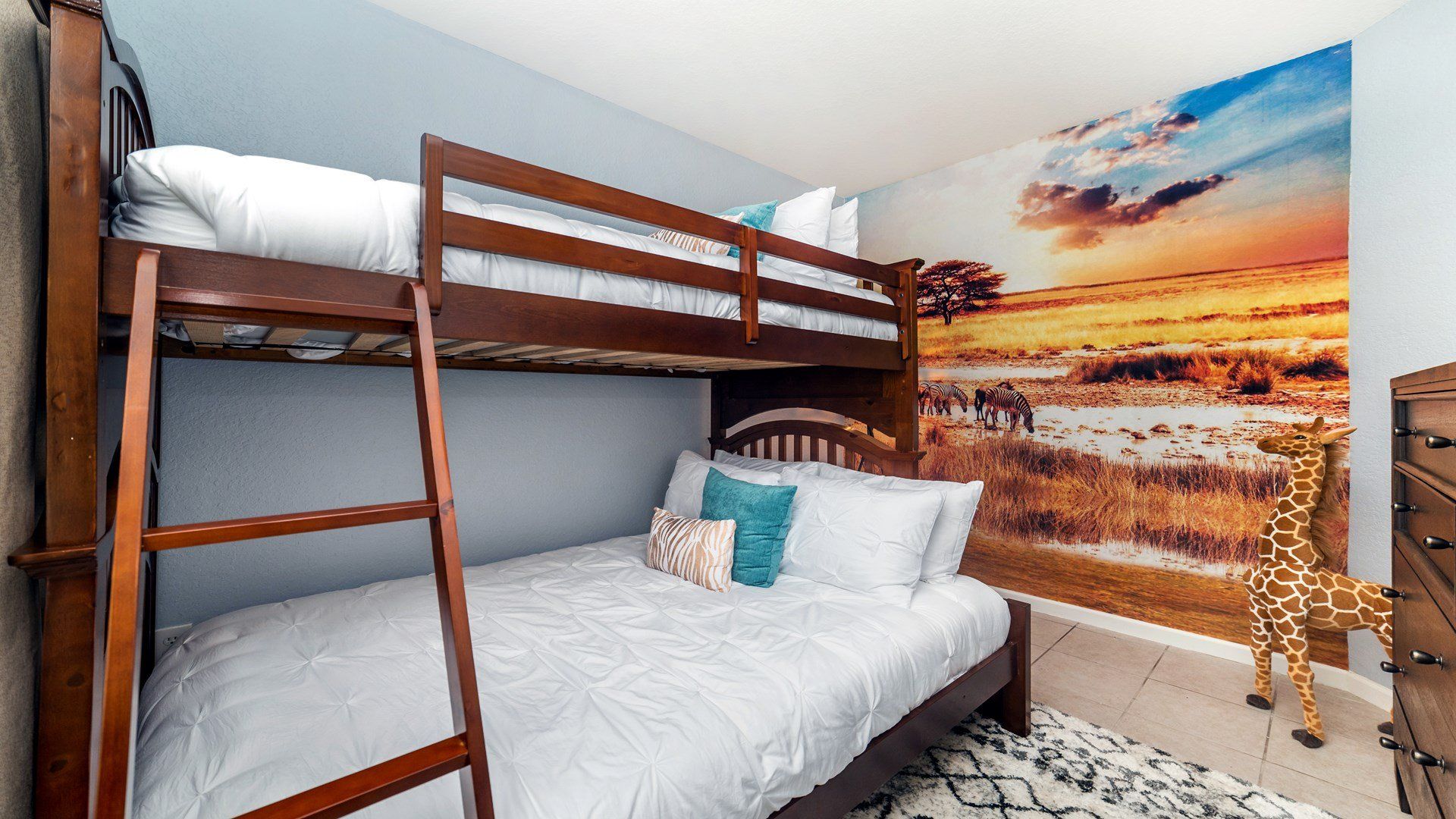 Adventure-themed kids' room with bunk beds and a stunning safari mural.