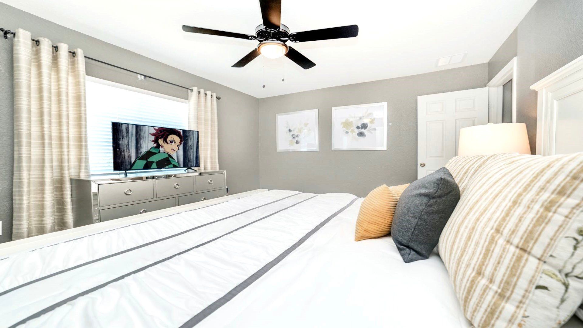 Cozy bedroom with soothing grey tones and a sleek, modern media setup