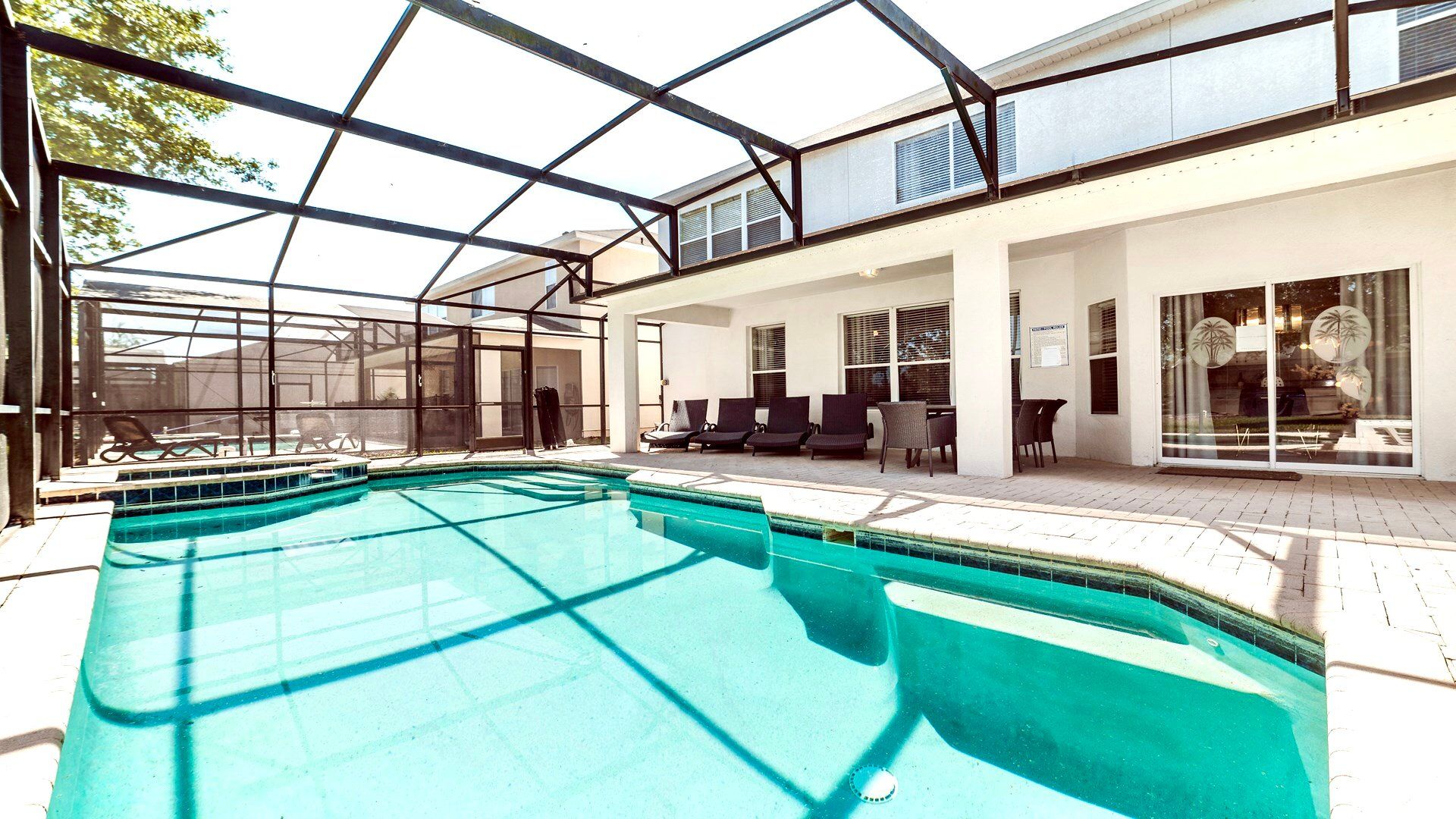 Sunny poolside retreat with a spacious patio and refreshing turquoise pool.