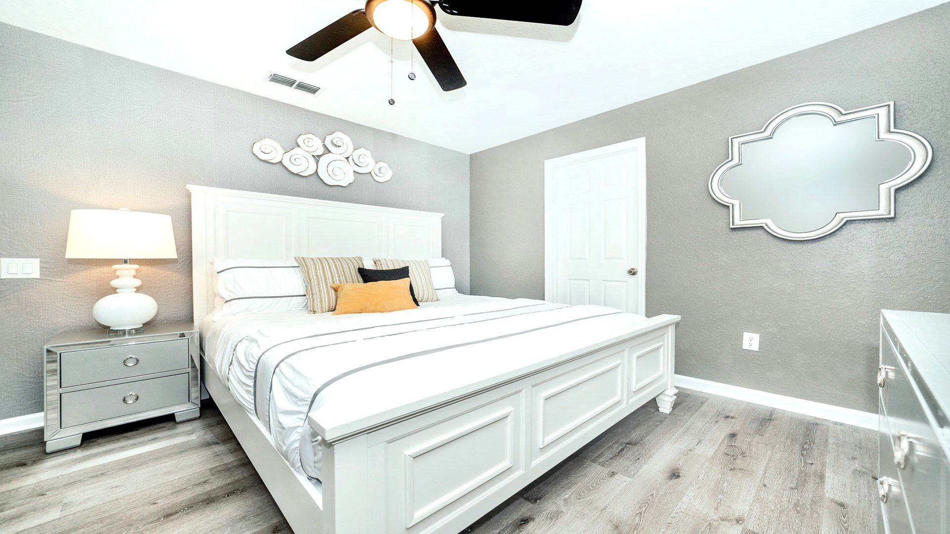 Bright, airy bedroom with artistic wall decor and a chic white theme.