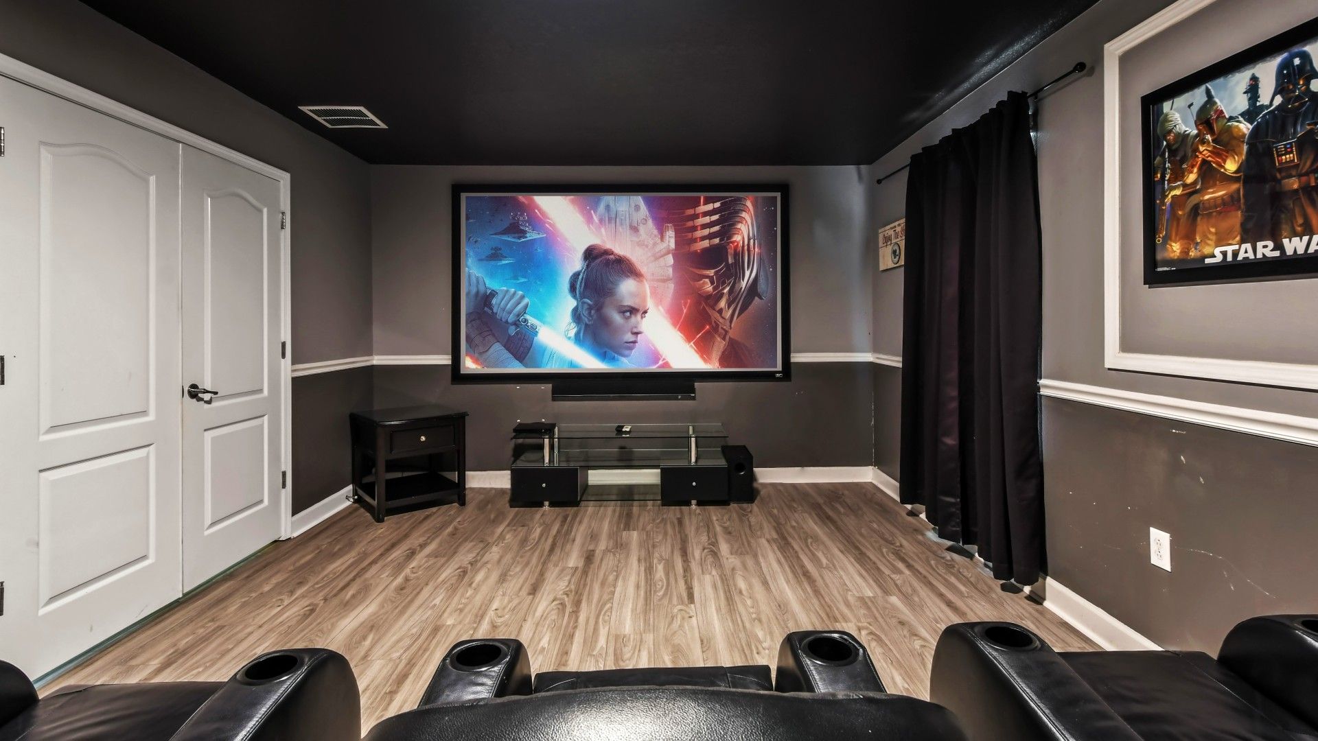 Dedicated movie theater equipped with plush seating, a large screen