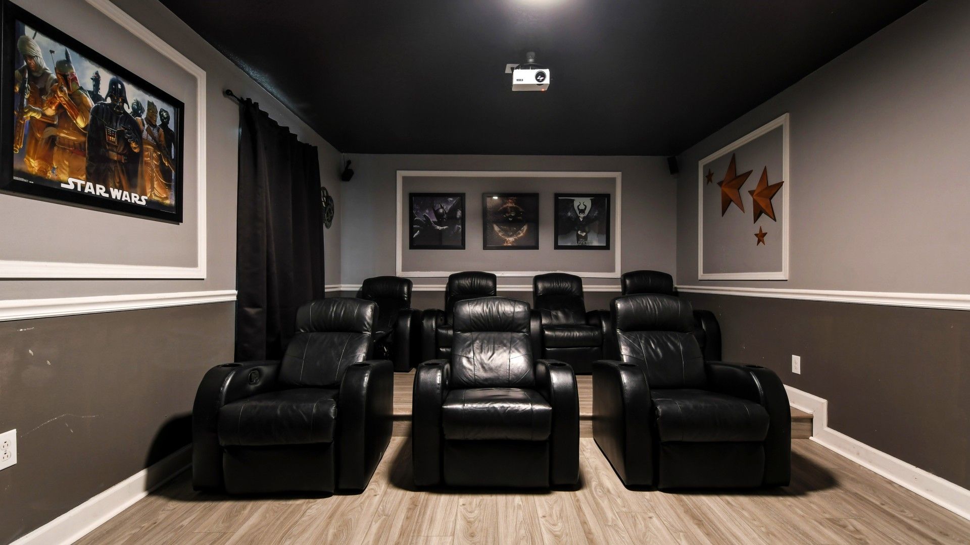 Dedicated movie theater equipped with plush seating, a large screen