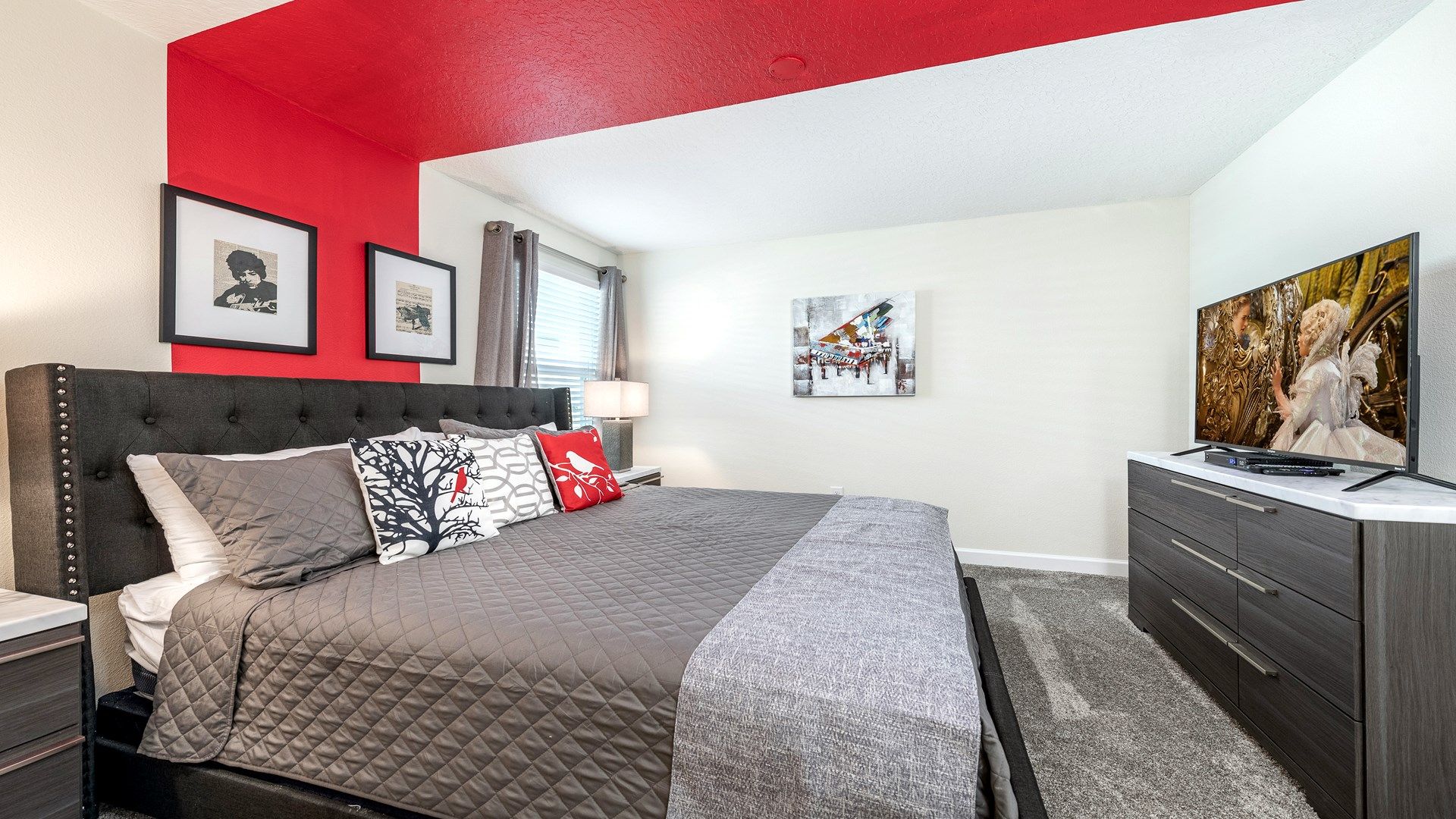 Chic bedroom oasis featuring a bold red accent wall and elegant decor accents.