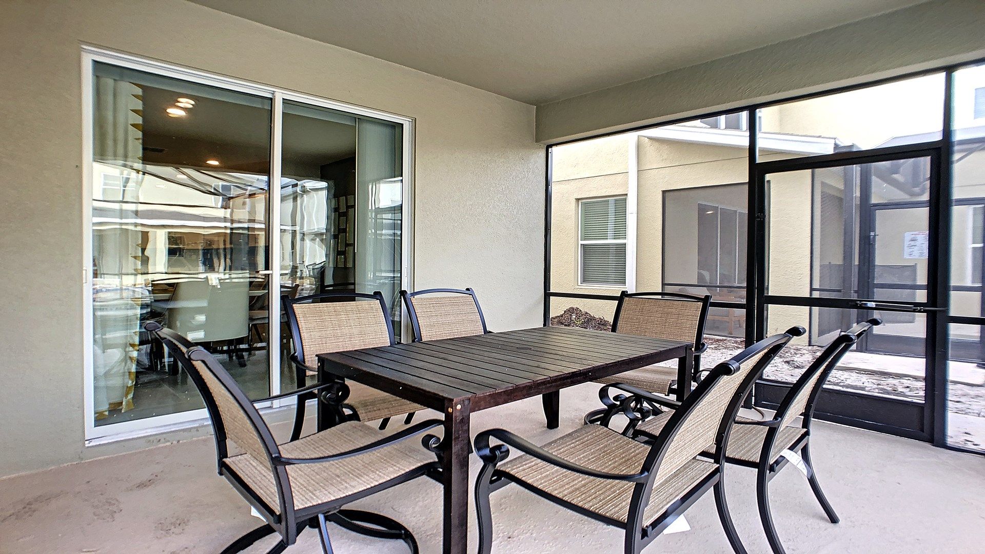 Enjoy outdoor dining on this spacious screened patio with a stylish six-seat table.