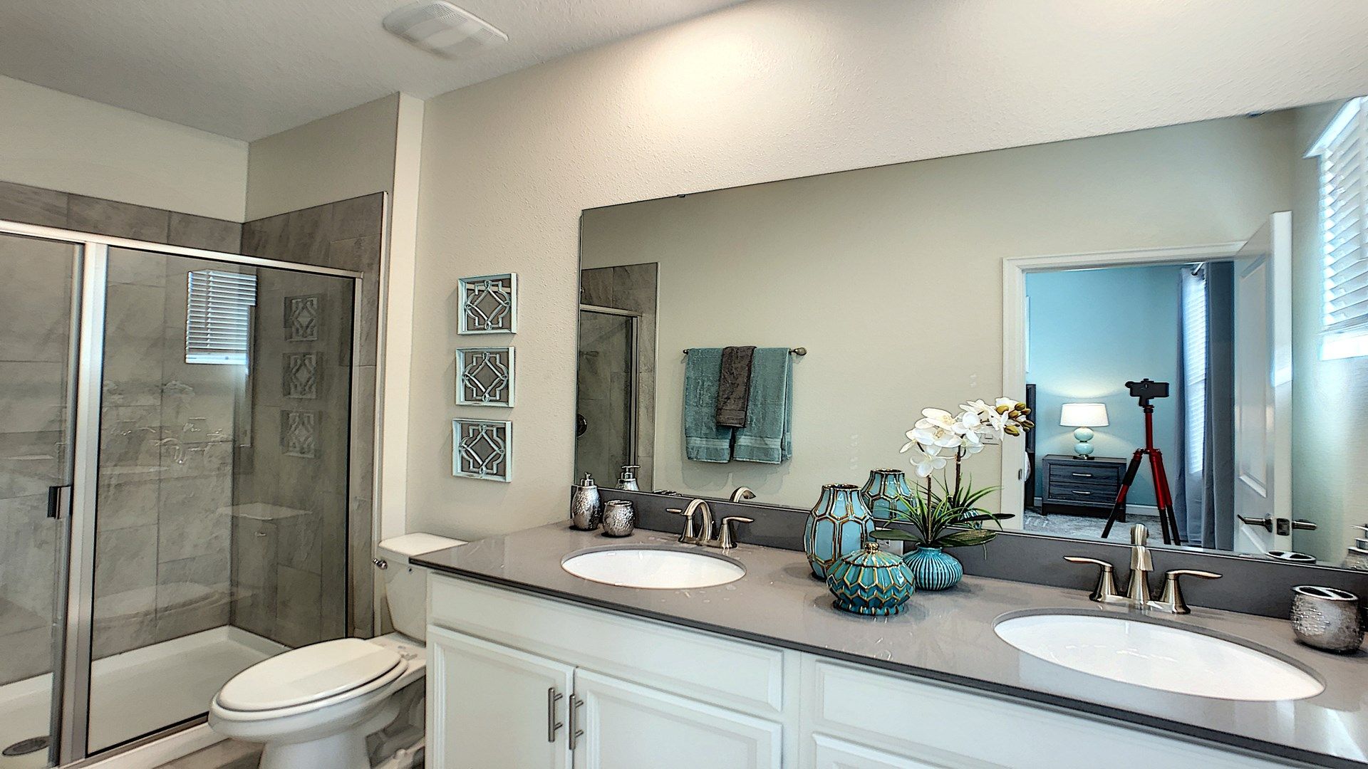 Elegant bathroom with a spacious glass shower, double vanity, and modern décor.