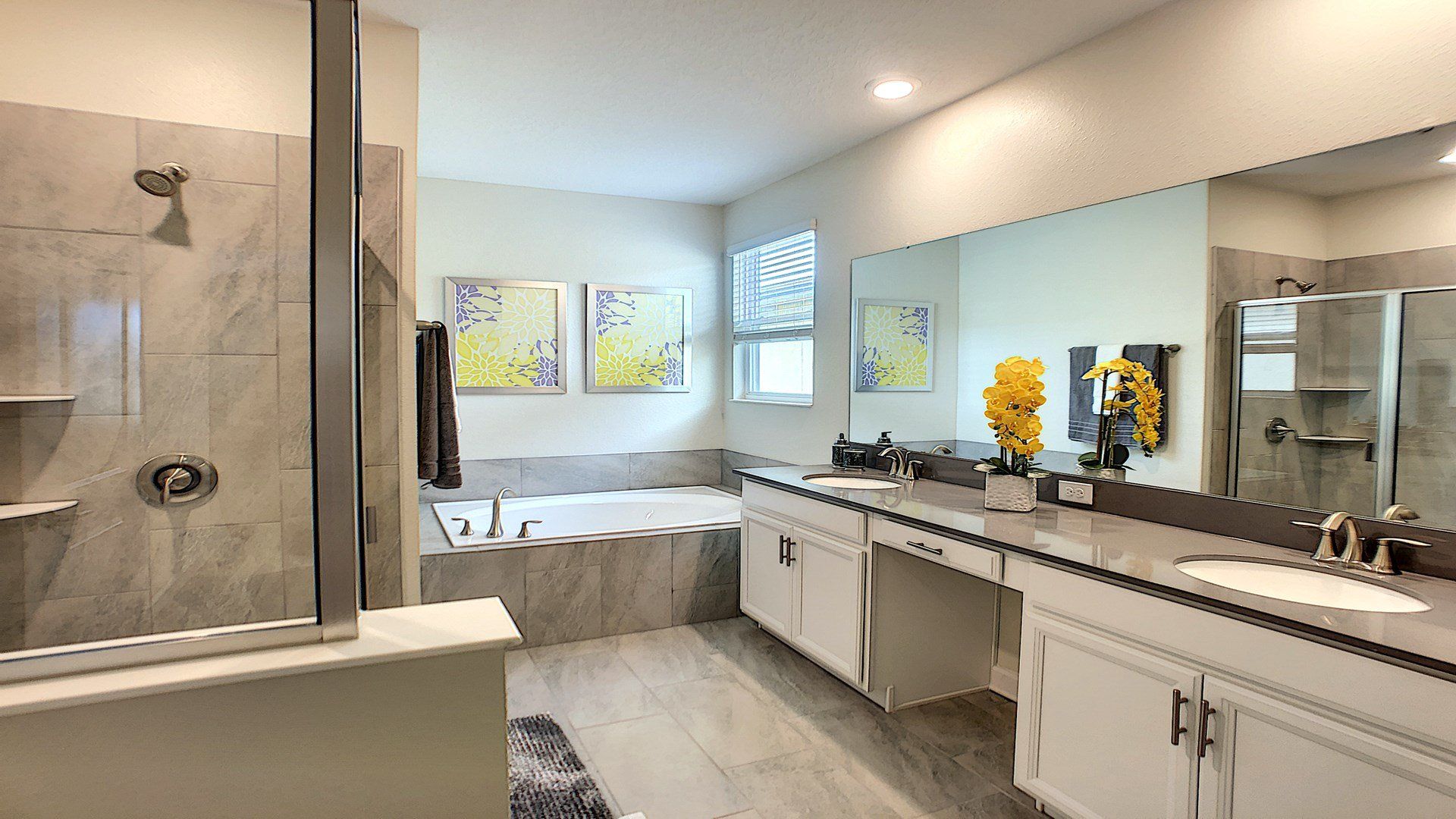 Spacious spa-like bathroom with a soaking tub, glass shower, and dual vanity sinks.