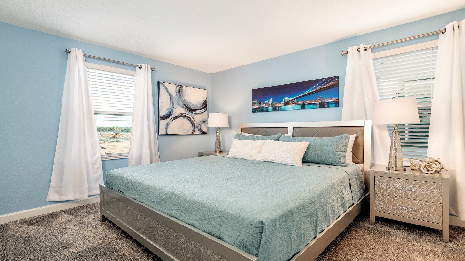 Serene bedroom with cool blue tones, elegant artwork, and a refreshing vibe.