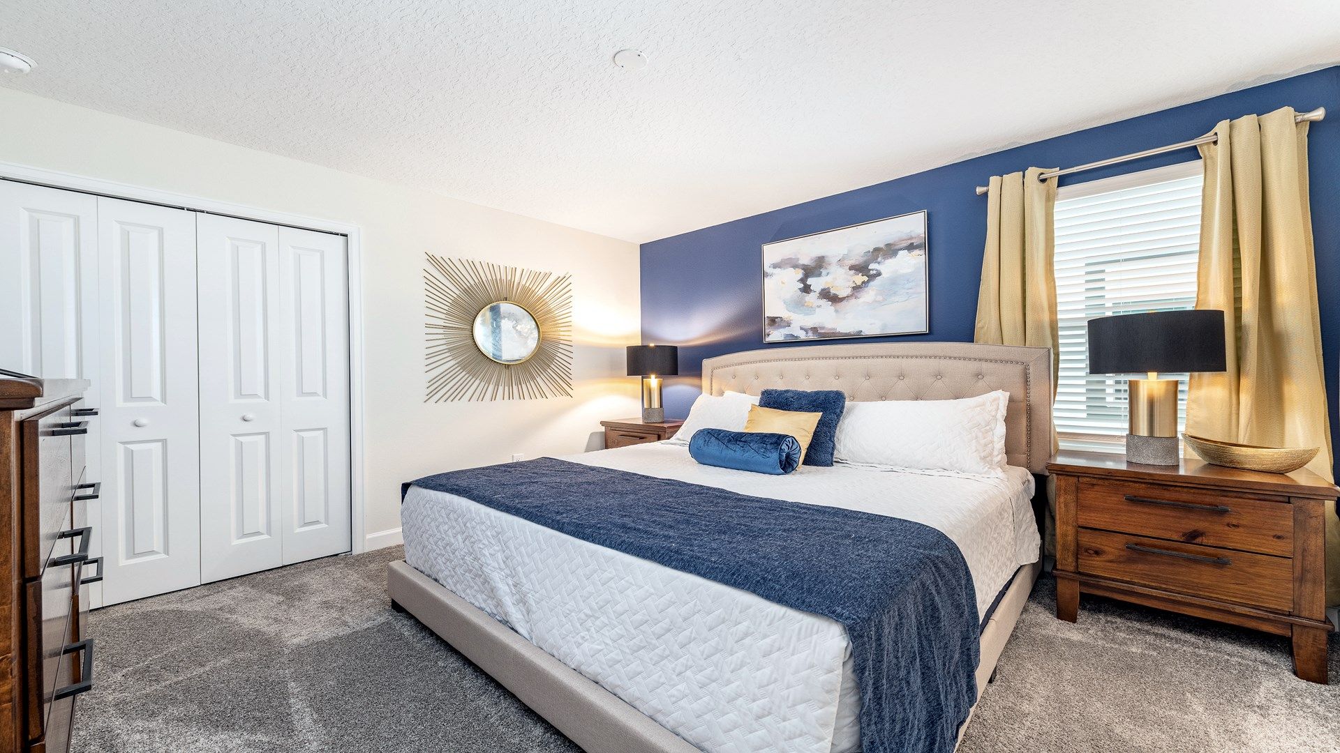 Chic bedroom with navy accents, gold decor, and cozy furnishings.