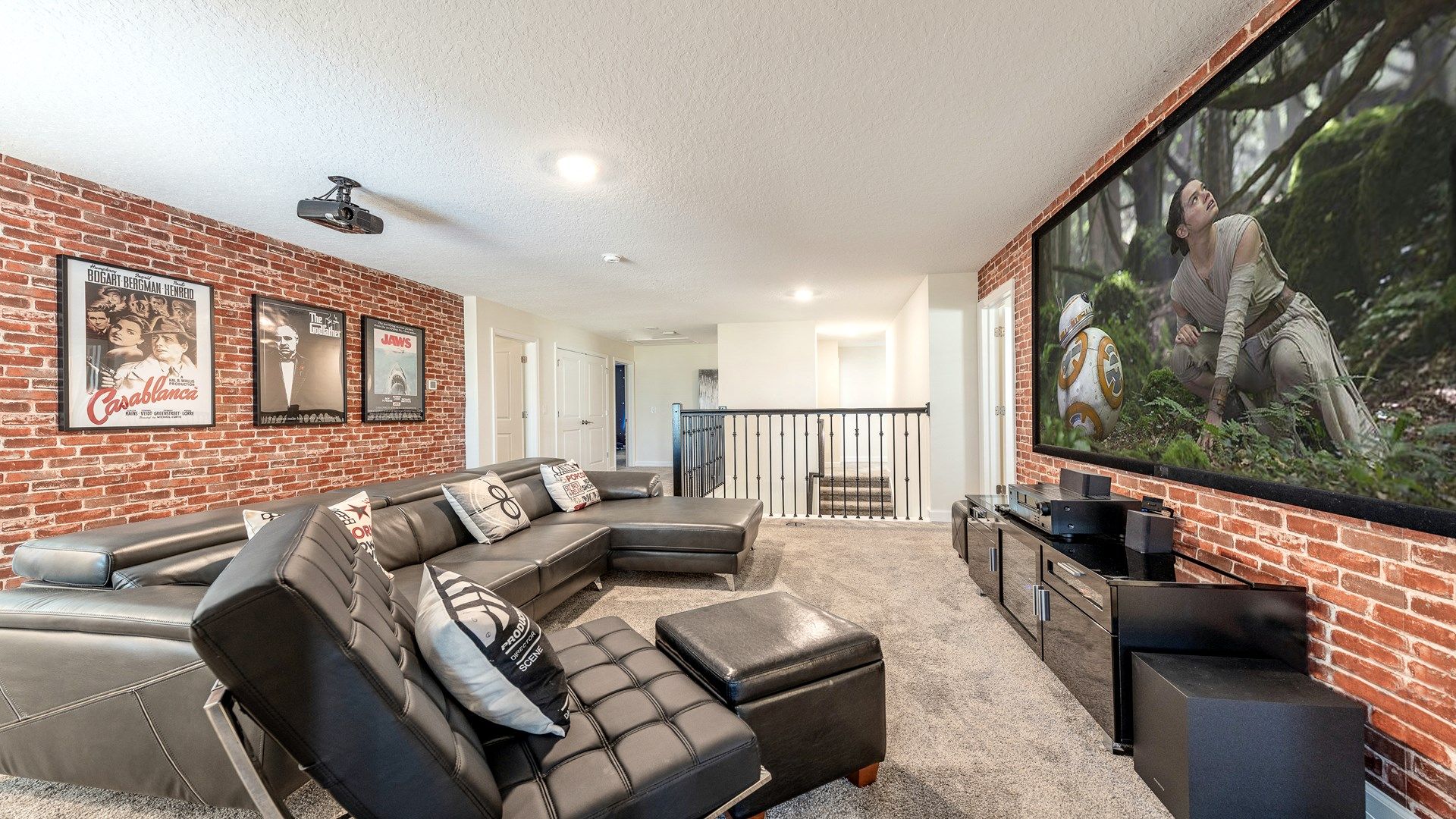 Cozy home theater with leather seating, brick accents, and a large screen