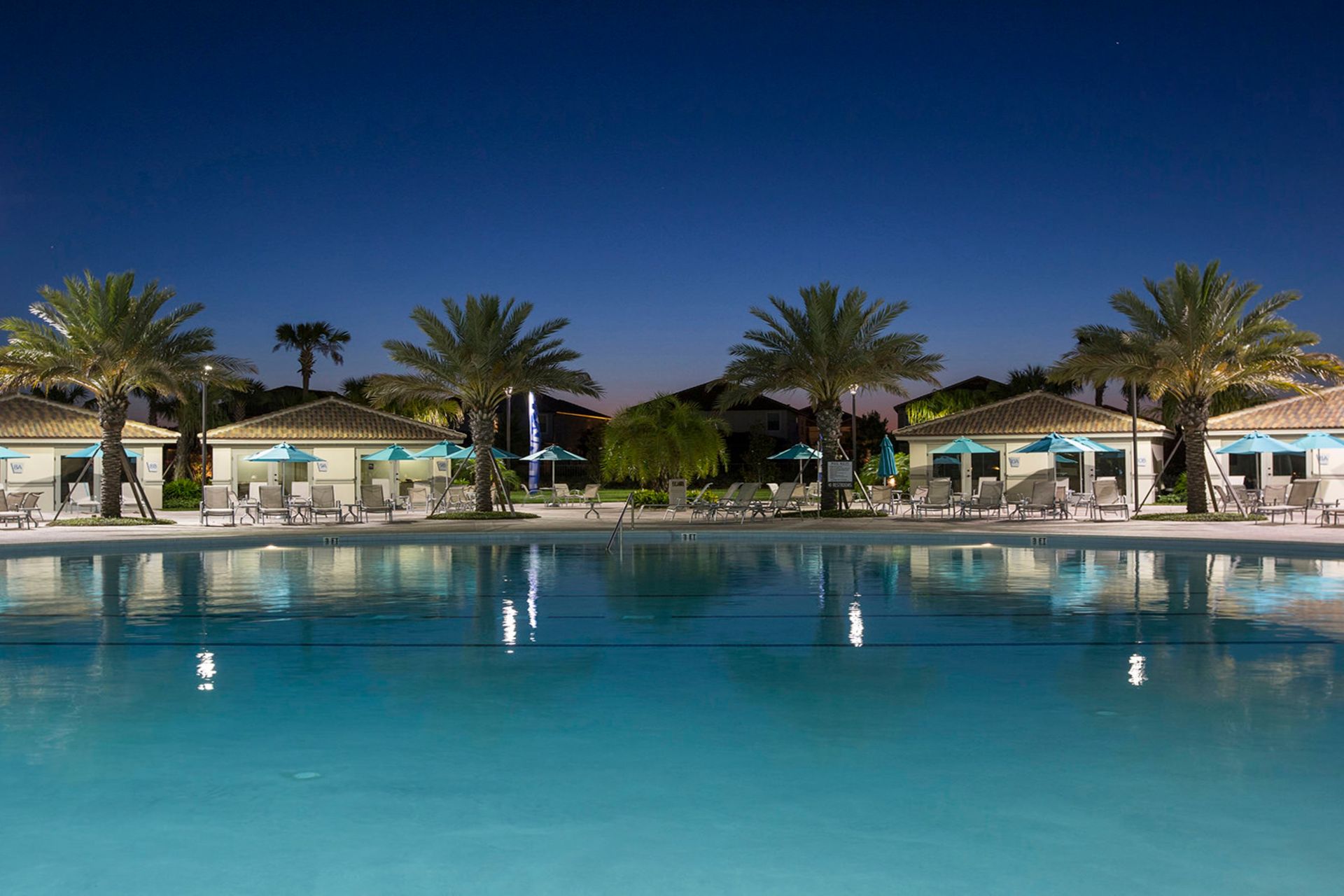 Serene resort's night pool scene with palm trees and gentle lighting for perfect evenings.