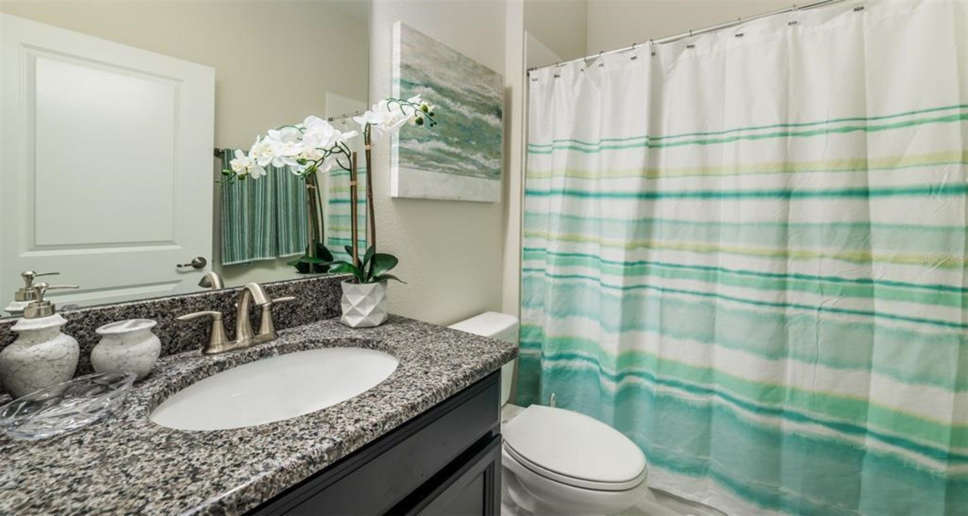 Bright and stylish bathroom with granite vanity and calming coastal tones.