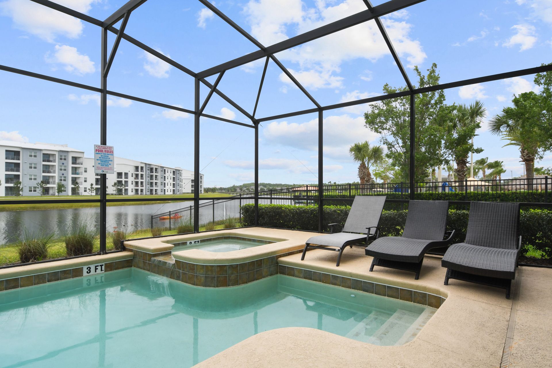 Screened private pool and spa with loungers and tranquil lakefront views.